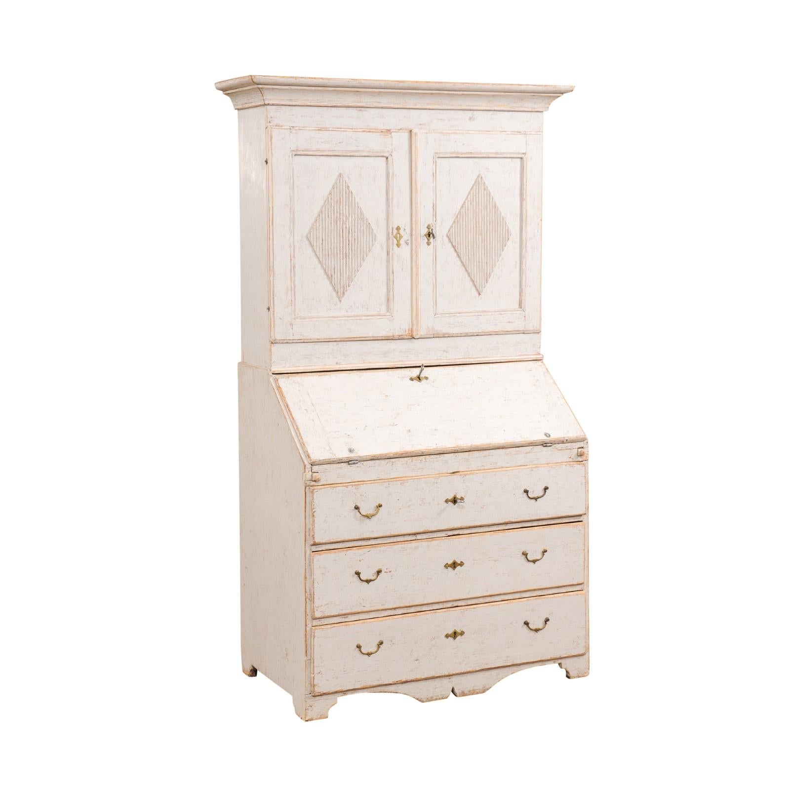 A Swedish Late Gustavian period two-part painted wood secretary from the early 19th century, with two doors, slant-front desk, three drawers, diamond motifs, bracket feet and nicely weathered patina. Created in Sweden at the end of the Gustavian