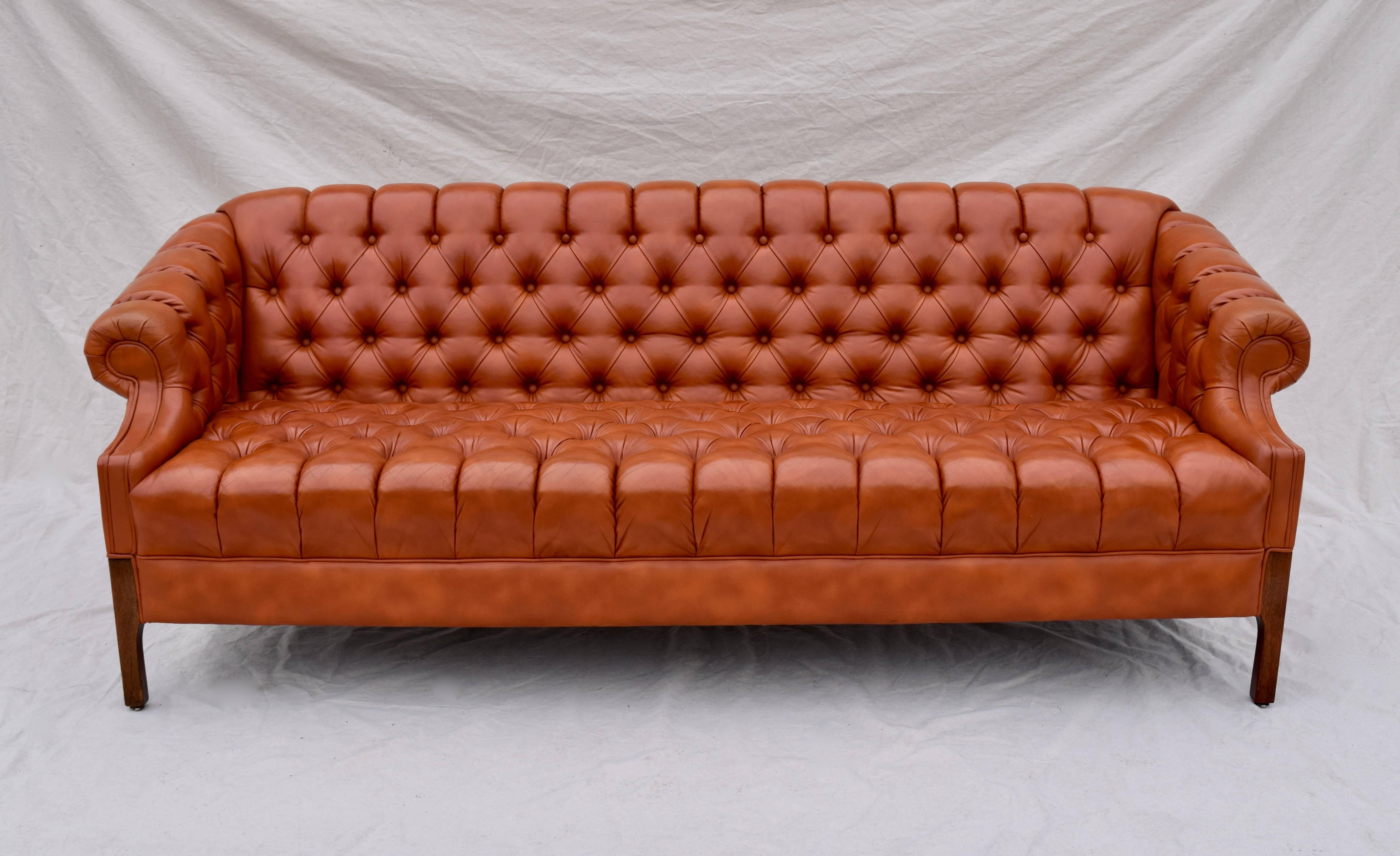 A Swedish leather Chesterfield sofa with deep button tufted back and arms, sitting on raised, lithe solid rosewood legs. Extraordinary comfort in exceptional vintage condition throughout, rarely used. Measures: Seat 17.5
