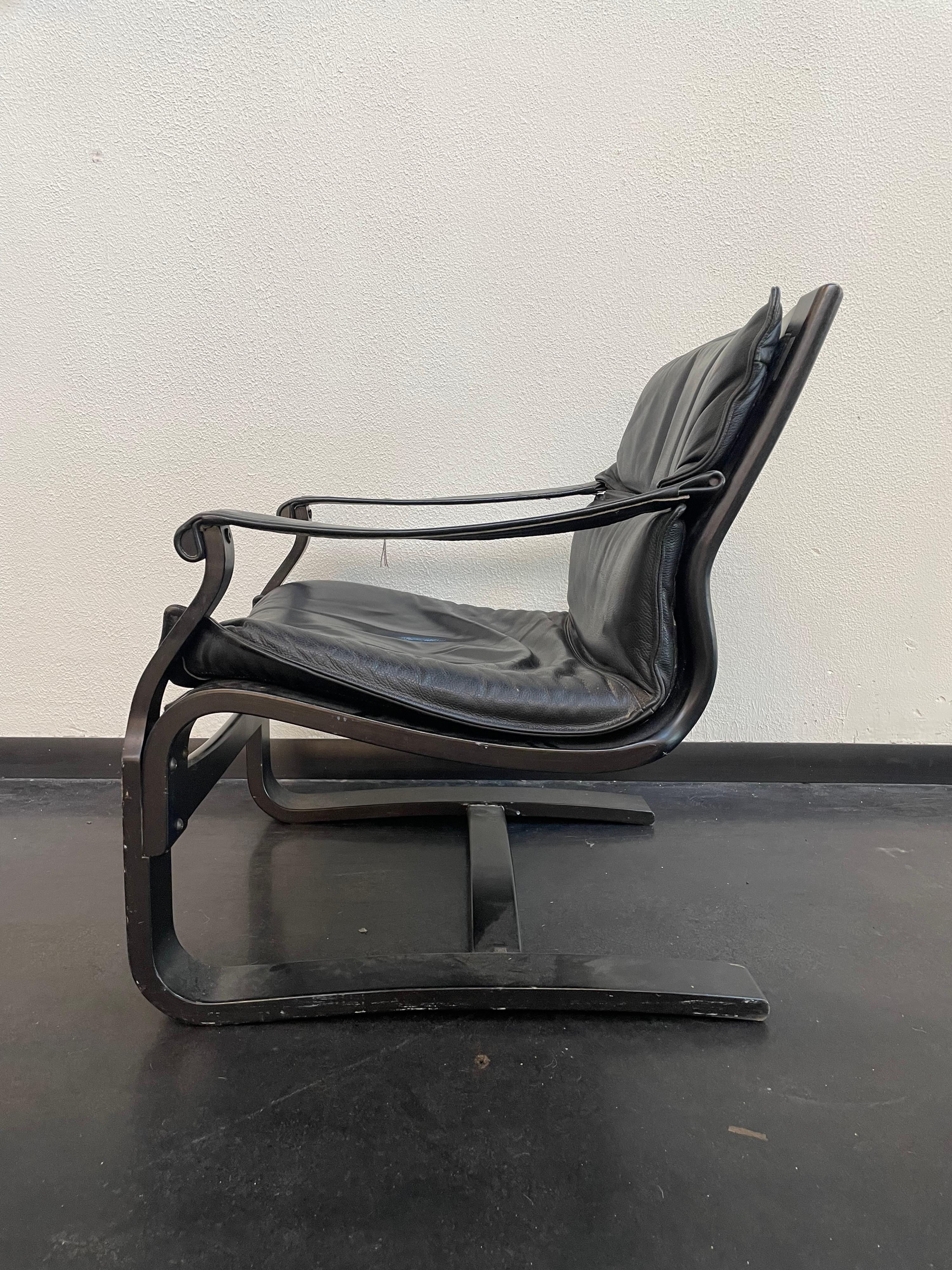 Vintage Swedish Black Leather Lounge Chair. Designed by Åke Fribytter. Manufactured by Nelo in Sweden. A cool cantilevered frame of ebonized bent plywood with original leather upholstery.