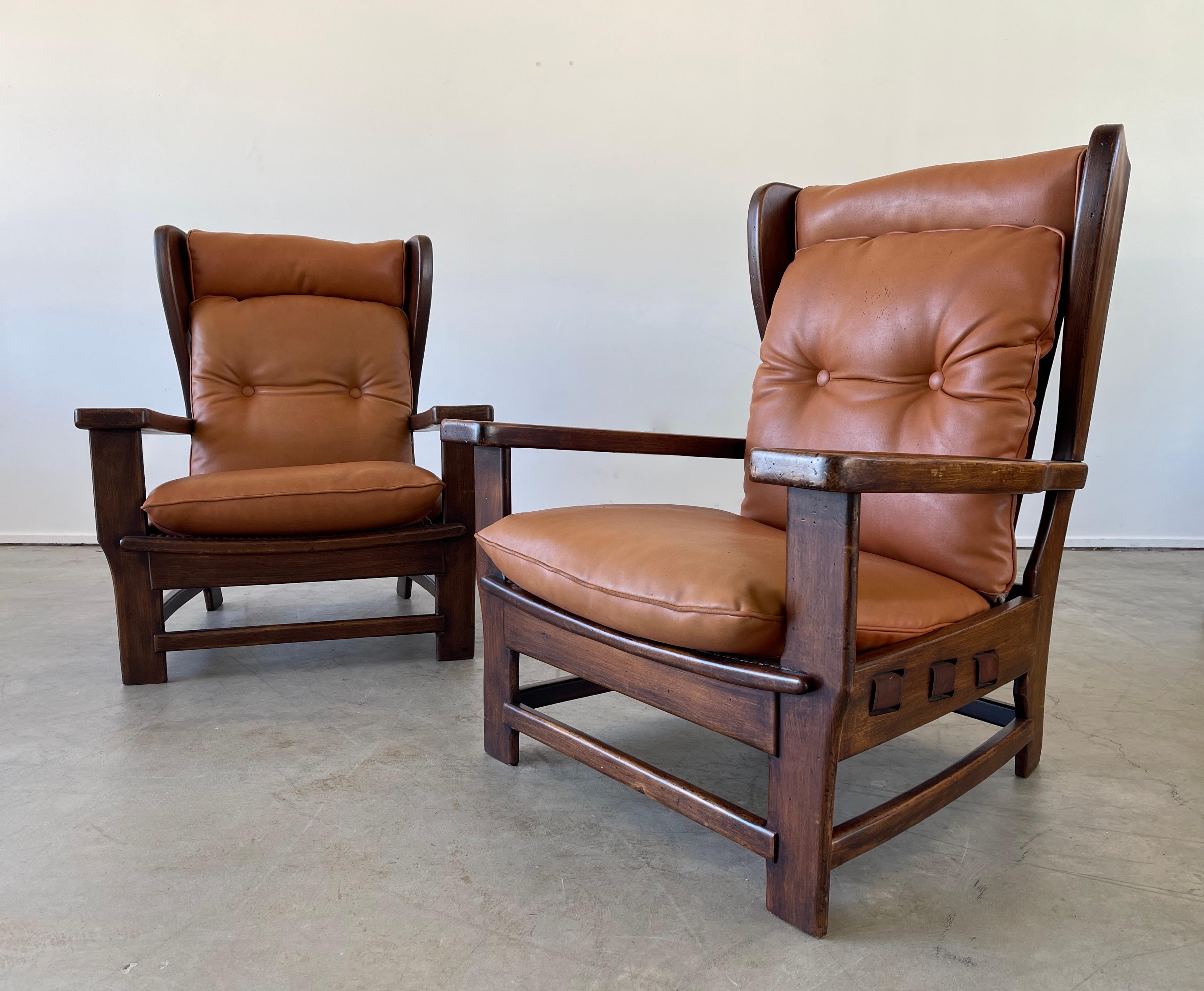 Unique pair of Swedish wingback chairs with walnut frame and original leather cushions and woven strap detail. 
Wonderful curved wingback shape - and warm patina to wood.