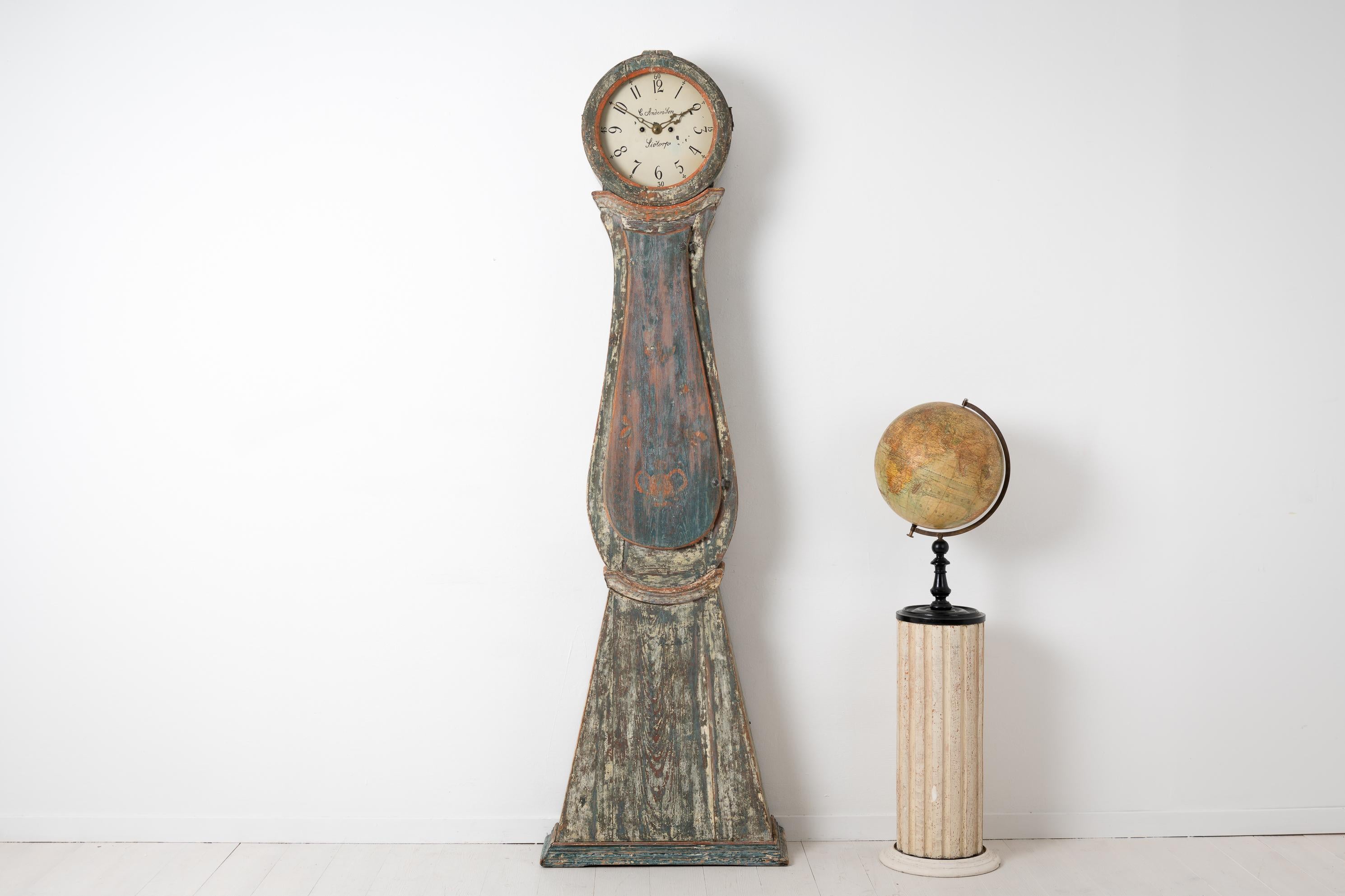 Long case clock from Sweden made during the early 19th century, around 1820 to 1840. The clock has a rococo shape with the original blue green paint where the multiple tones of the paint contributes to the genuine antique character. The case is