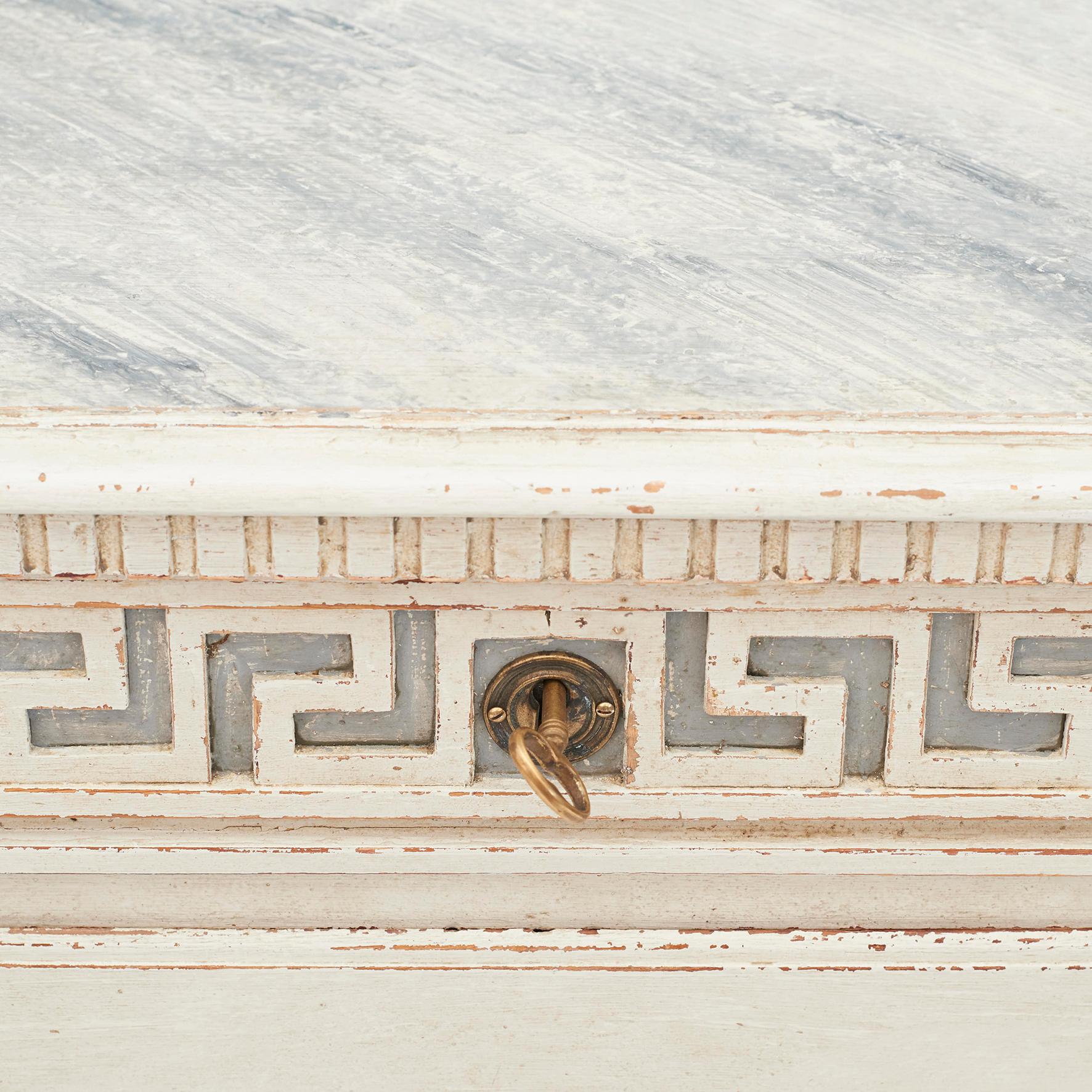 Swedish Gustavian / Louis XVI chest of drawers. Grey-white painted, top grey marble painted. 3 lockable drawers with brass fittings. One key. Top drawer with Grecian key pattern, fluted columns on each side. Sweden approximate, 1730-1740.