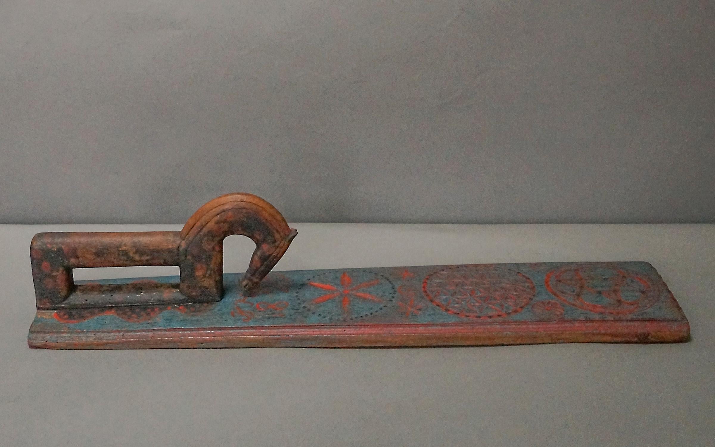 Charming hand-carved Swedish mangle board dated 1829. The beautifully carved horse-shaped handle has an arching neck and is painted with salmon polka dots. The dots continue onto the board itself to pool at the horse’s feet. Further along, the board