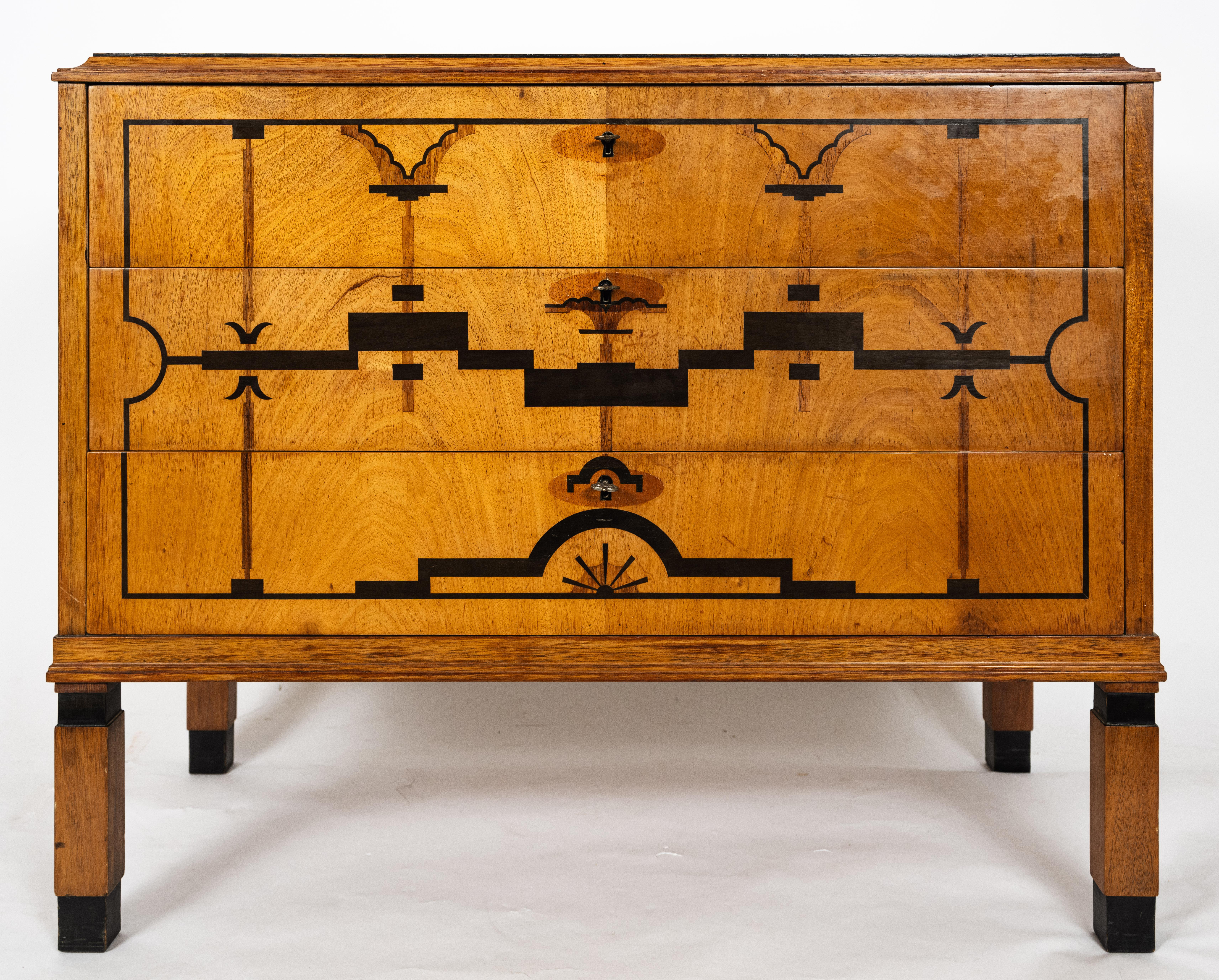 A 1930s Swedish Art Deco chest made of inlaid elm with rosewood and walnut veneer. having stylized geometric details, square legs, and three drawers. 