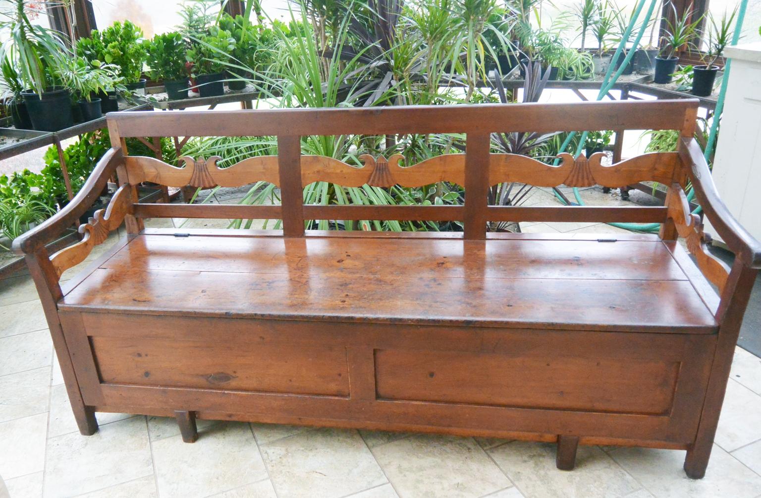 Swedish country long bench with pine carcass and carved maple slats. The fan carving of the wavy slats is an unusual detail for a country bench but one that lifts it from the mundane to the interesting. The seat hinges up to reveal a large storage