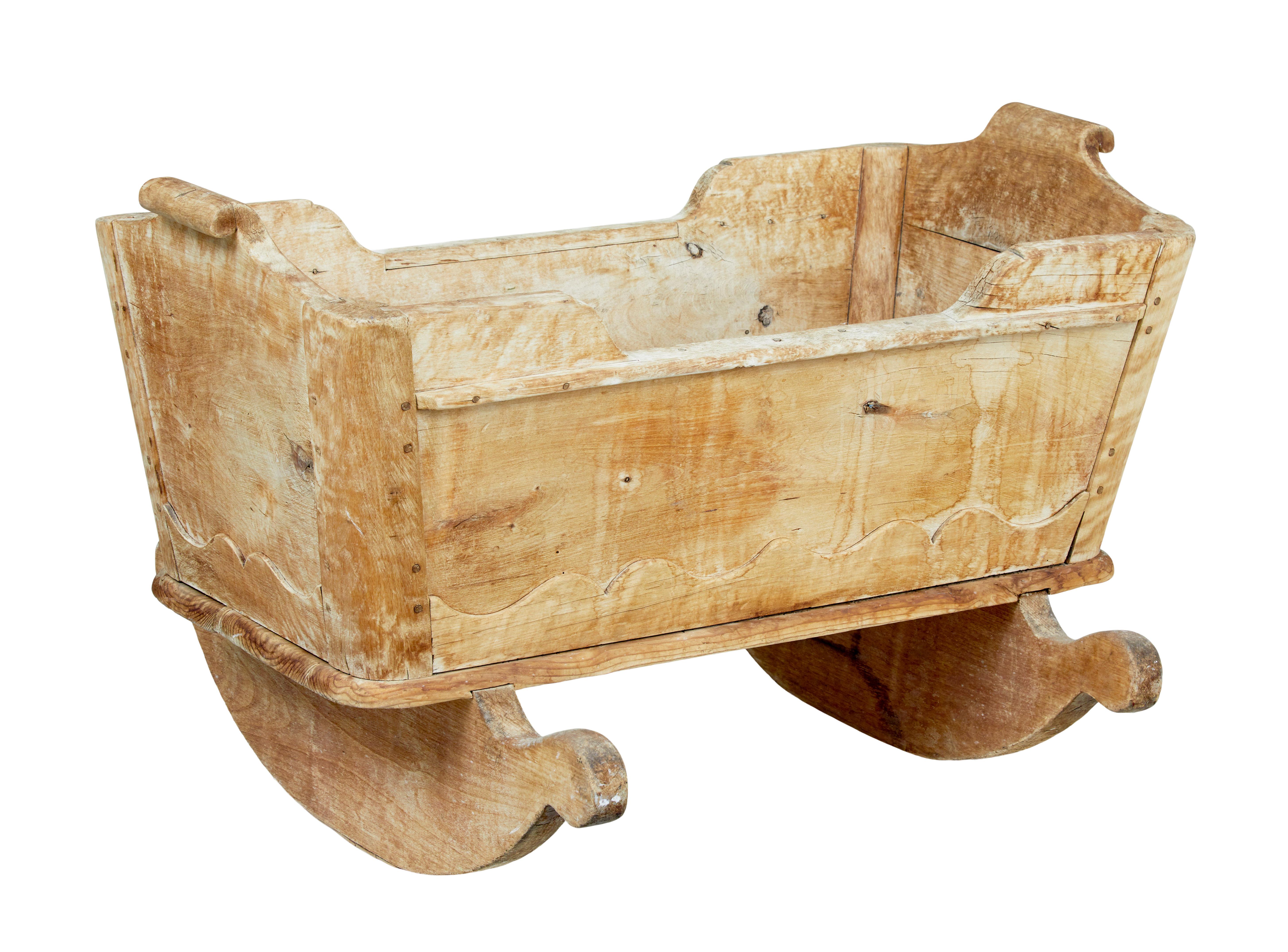 Swedish mid 19th century carved pine rocking cradle circa 1840.

We are pleased to offer this piece of traditional swedish furniture.  Made from solid heavy pine, likely to have been painted but presented in scraped back bare wood.

Scrolled handles