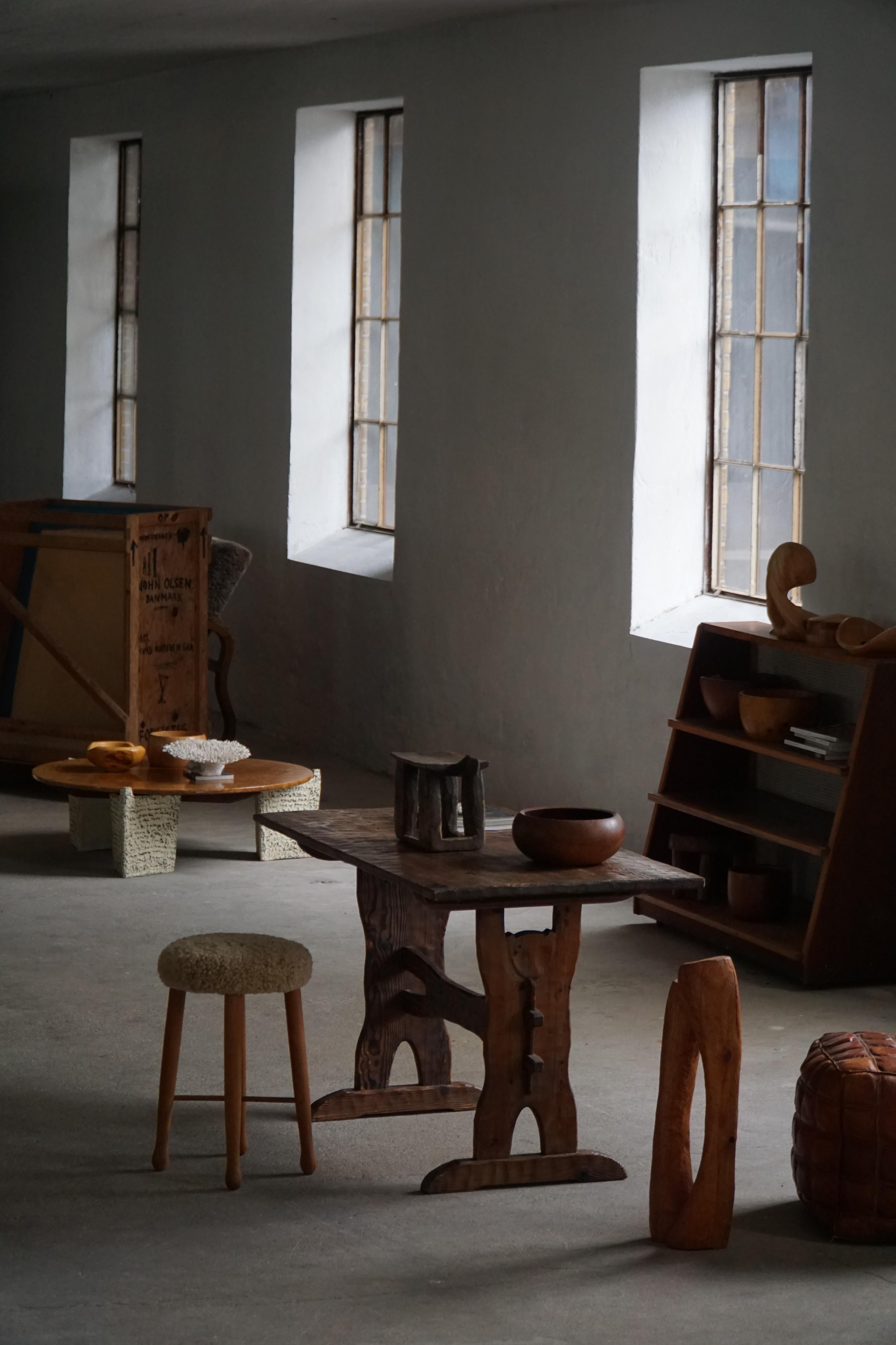 Cette table suédoise expressive du milieu du XXe siècle est une pièce magnifiquement fabriquée à la main en pin massif, mettant en valeur une approche organique et sculpturale de la menuiserie et de la forme. La table présente un plateau