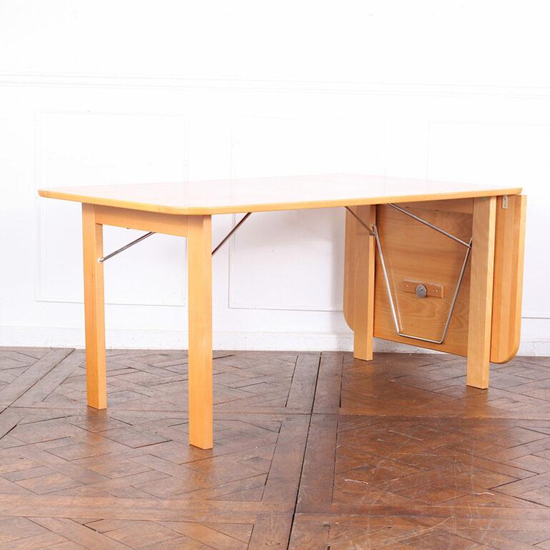 A late 20th Century Swedish extending table in beechwood with a drop-leaf at one end to extend the table. Simple clean lines; folding legs to store flat if necessary. 