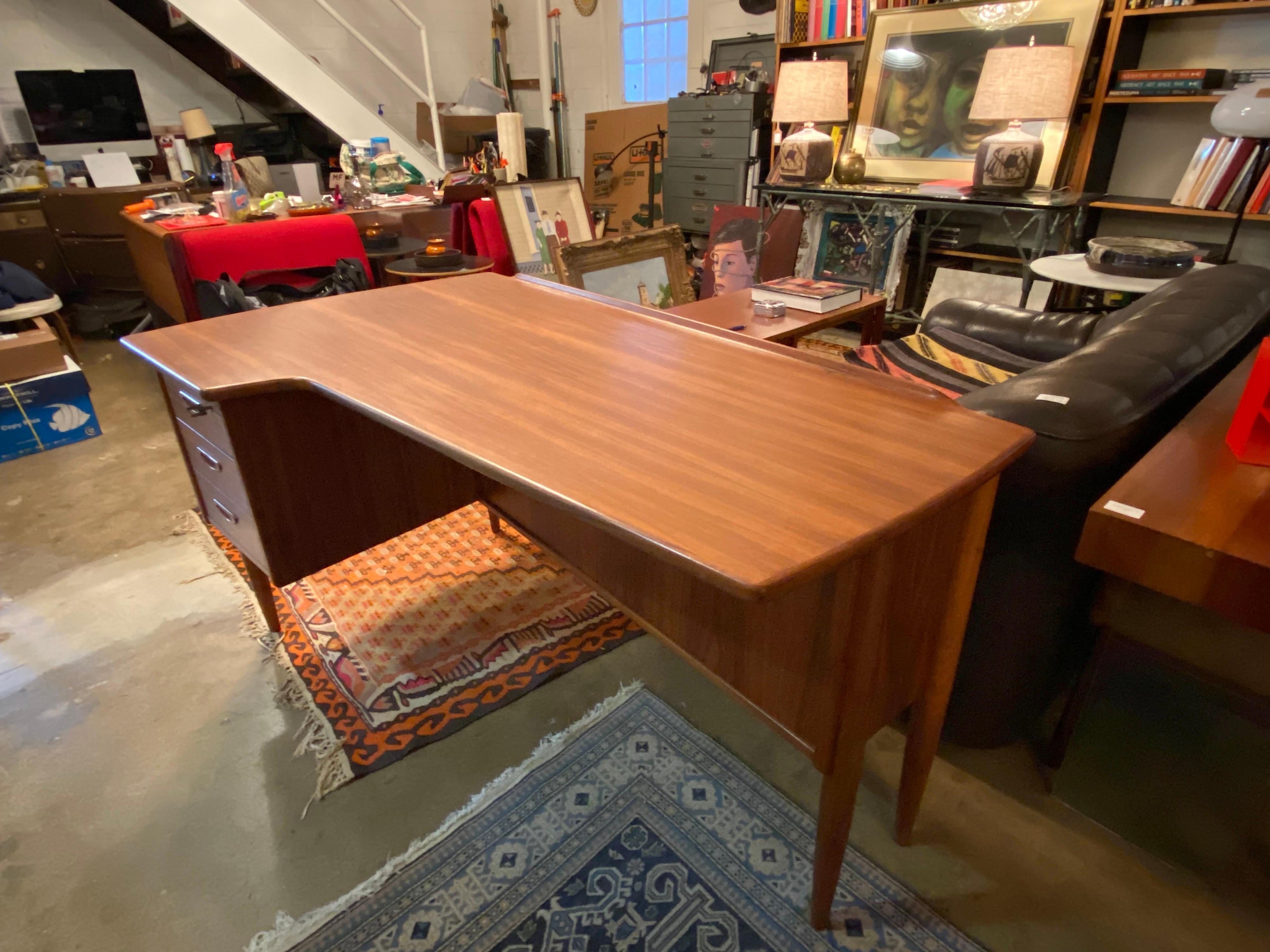 Beautiful Scandinavian Mid-Century Modern boomerang desk designed by Göran Strand made of teak features three drawers with key and back storage. This office desk is in great overall vintage condition.