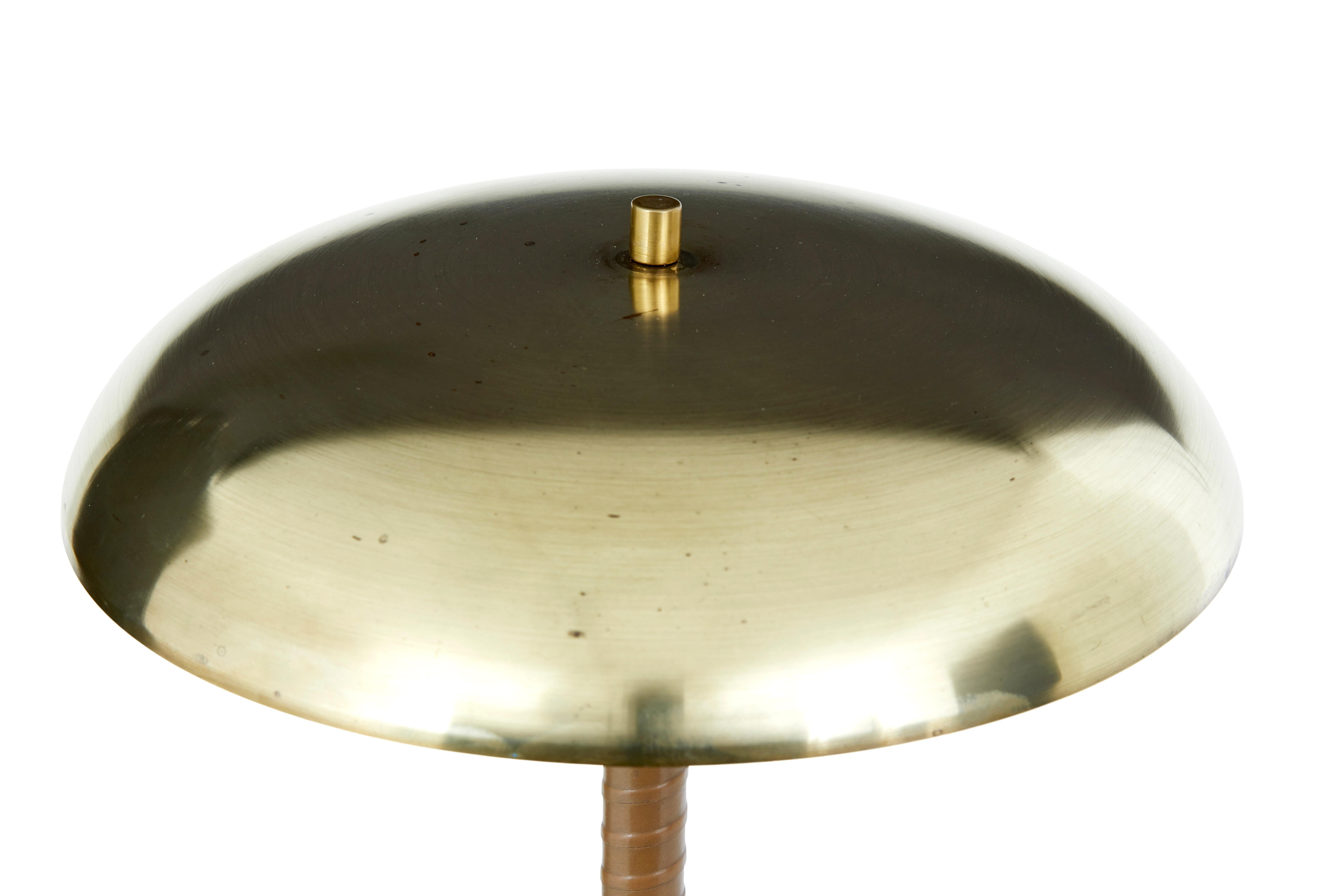 Swedish mid century brass and leather table lamp by borens circa 1960.

Fine quality borens boras desk/table lamp.  Brushed brass symbol top, with 2 bulb holders below, which reflect light down from the white painted underside.  Stands on a tan