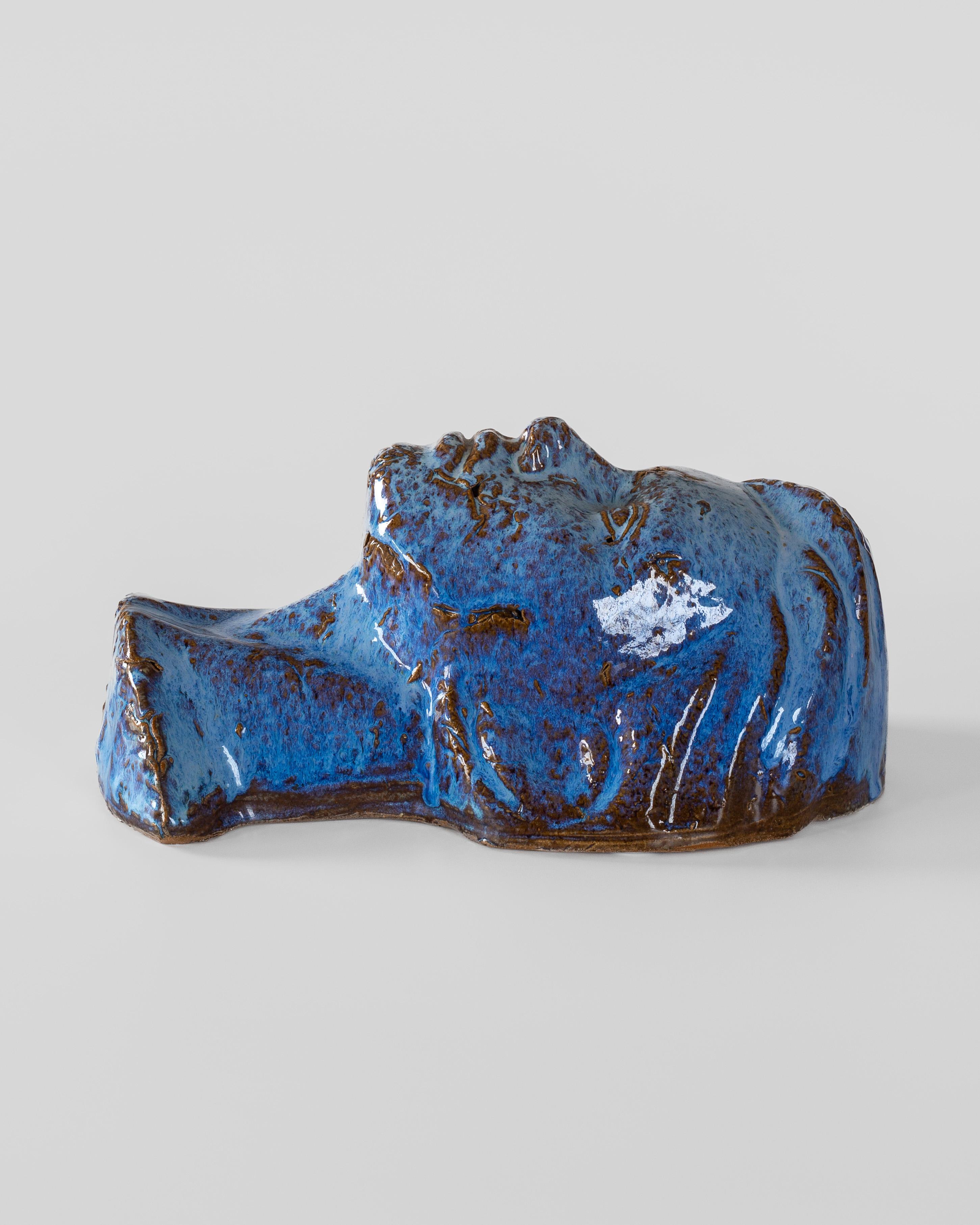 Striking mid-century Swedish ceramic mask featuring a masterful blue glaze with rustic brown undertones. This sculptural face/bust artwork showcases sophisticated glazing techniques, creating a mesmerizing play of light to deep cobalt blue, with