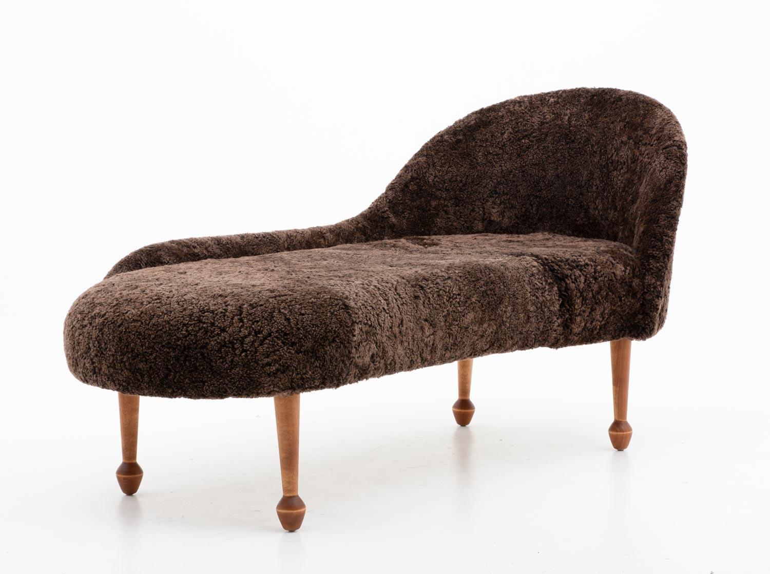 Swedish midcentury chaise longue in sheepskin, manufactured in Sweden, 1950s.
This chaise longue has a beautiful organic shape, supported by wooden drumstick legs. 

Condition: Completely restored and reupholstered in brown sheepskin by 1st