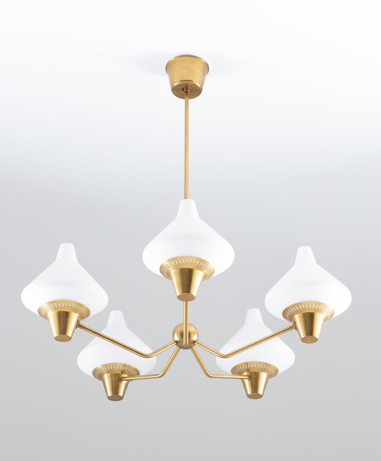 Chandelier in brass with shades of frosted opaline glass ASEA, Sweden, 1950s.
This small chandelier was made with an impressive sense for quality and design. Great details are the brass globe in the middle, and the perforated shade holders that