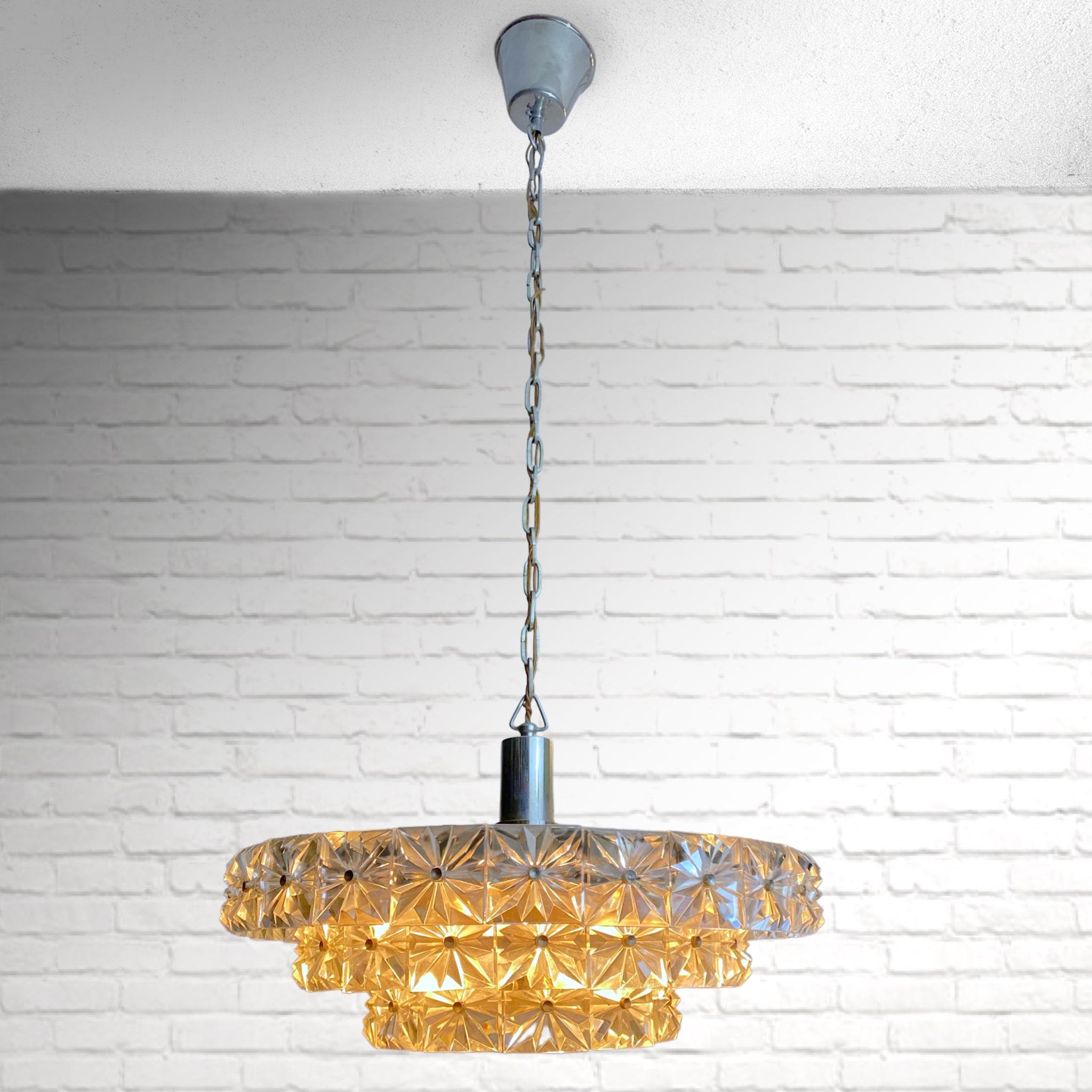 Mid-century chandelier produced in the 1960s by the Swedish manufacturer Eriksmåla. Constructed with 54 crystal elements mounted on a chrome frame, it features six metal lamp holders and a canopy made from chrome metal. The height can easily be