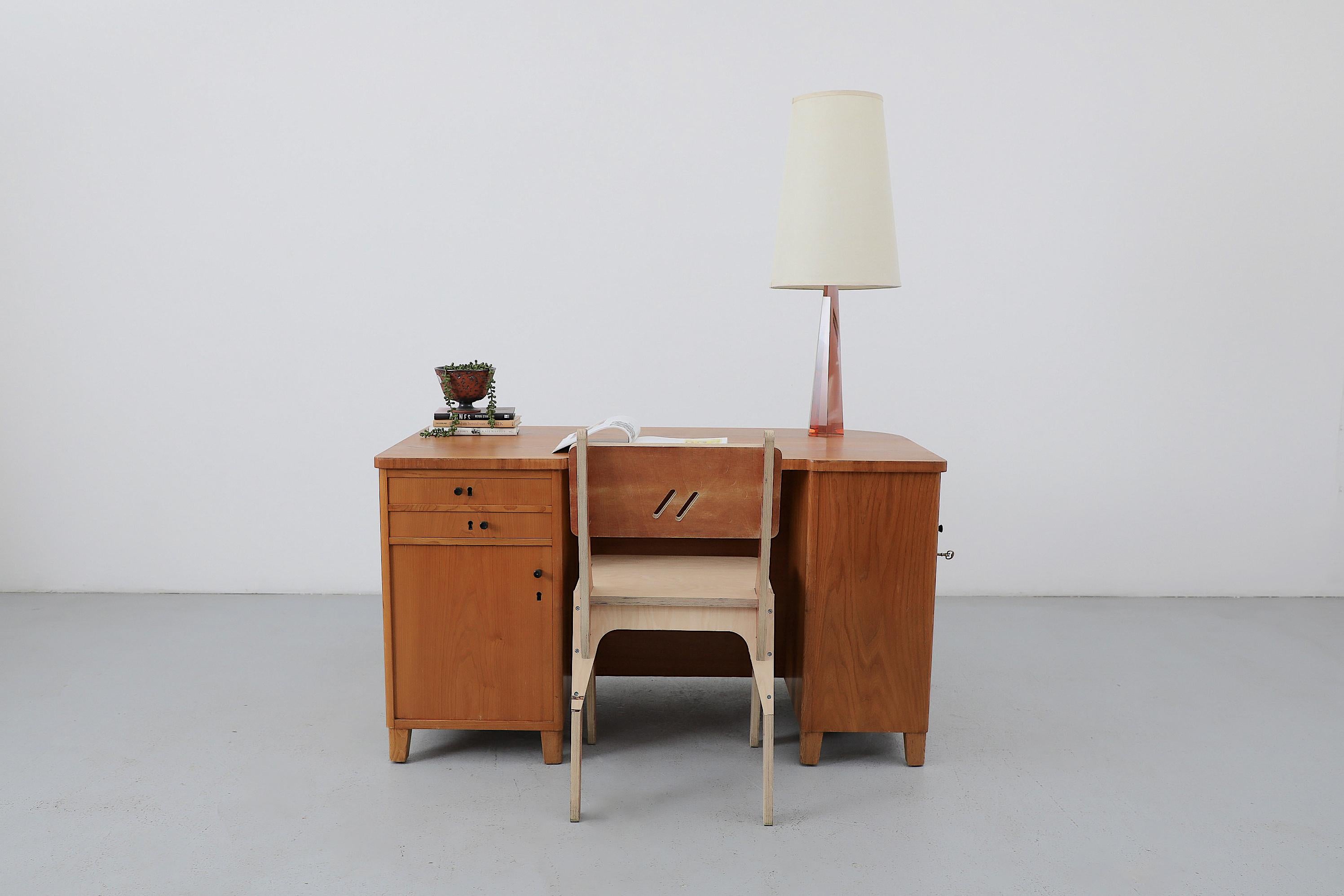 Scrivania in pino svedese del Mid-Century con un sottile armadietto laterale e una libreria integrata sul retro. I piccoli pomelli neri, posizionati in modo casuale, sono stati aggiunti dal precedente proprietario per facilitare l'apertura. In