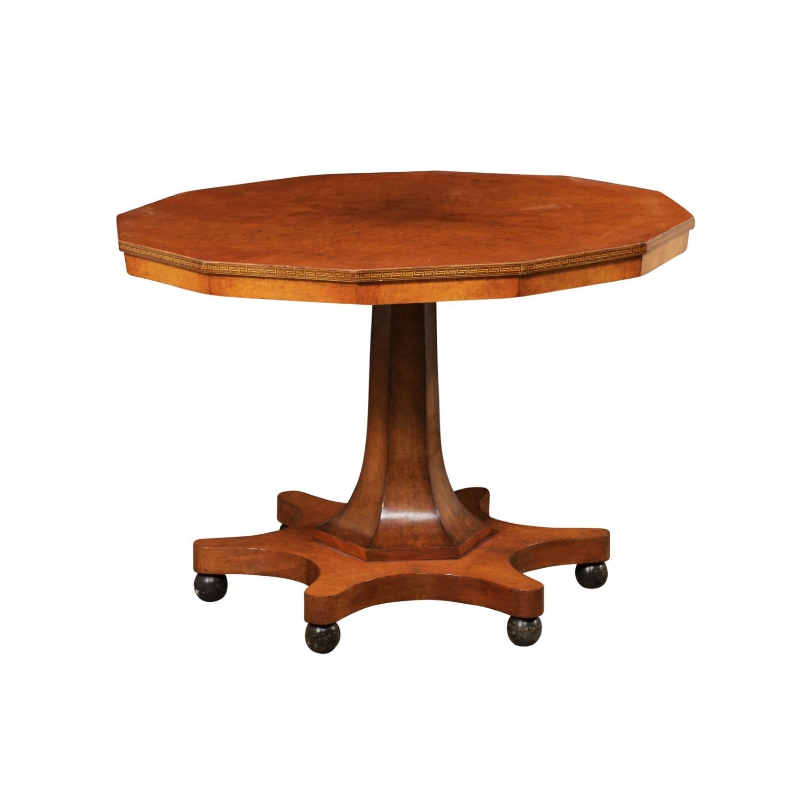 A Swedish shapely wooden pedestal table from the mid 20th century. This mid-century center table from Sweden has a unique dodecagon shape (a 12-sided polygon) at it's top, with a Greek key trim outlining it's perimeter, which supported atop an