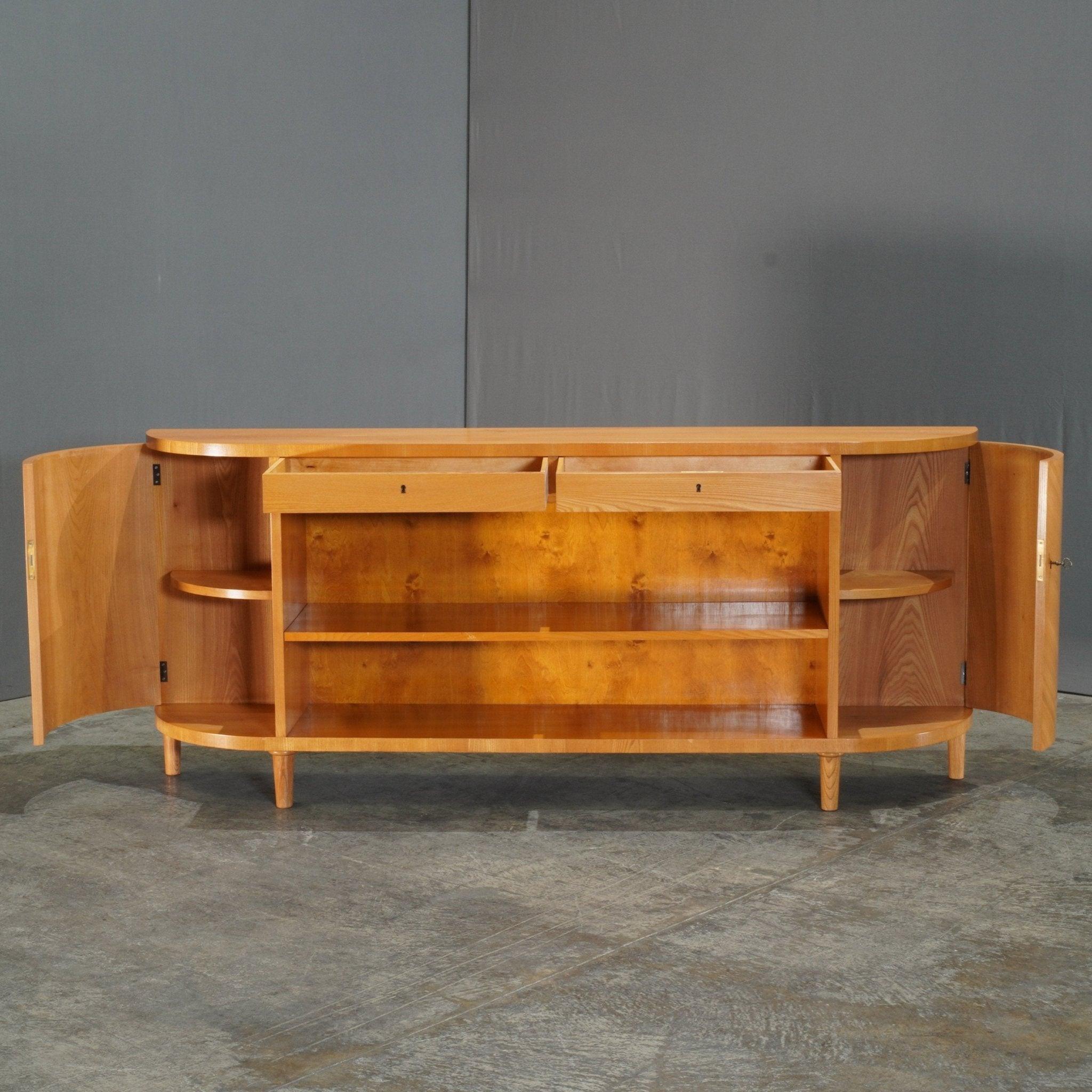 The Swedish Mid-Century Elm Sideboard exudes Scandinavian craftsmanship, offering a seamless blend of function and form. Constructed from beautifully grained elm, this piece boasts a sleek, minimalist design typical of mid-century modern aesthetics.