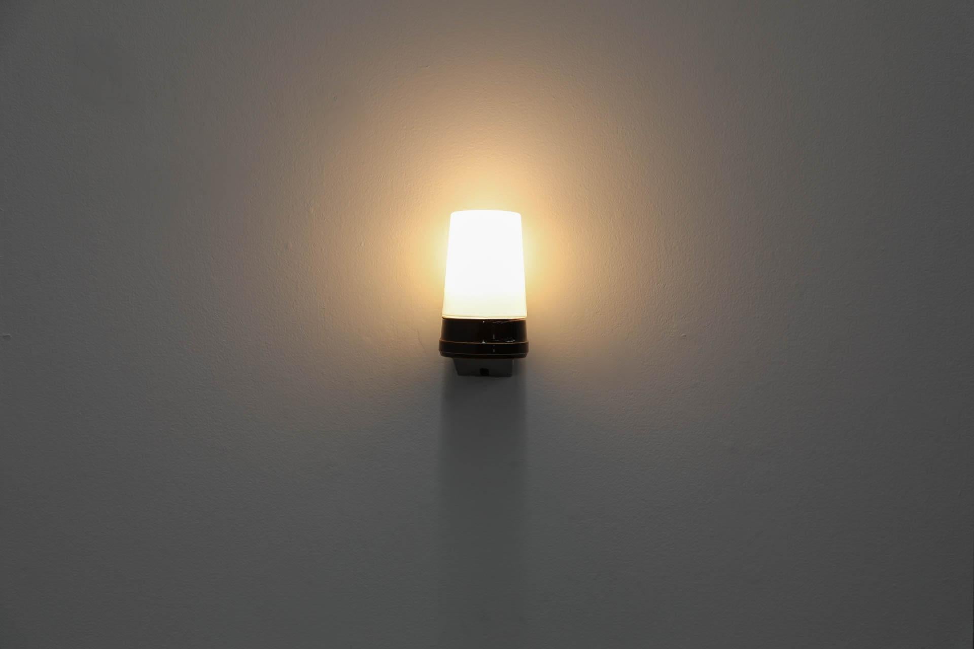 Designed by designer Sigvard Bernadotte for the IFÖ company in the middle of the 1960’s, this beautiful, Bauhaus-inspired example of Swedish Mid-Century design features a white opaline glass shade that screws on to the rich brown glazed ceramic