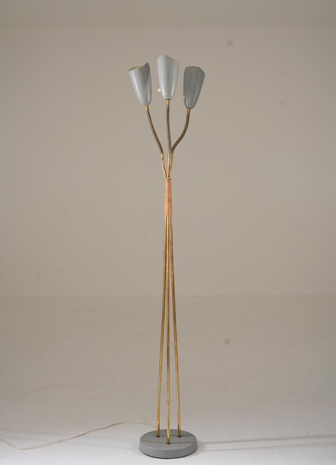 Si tratta di un'incantevole lampada da terra moderna di metà secolo, prodotta in Svezia negli anni '50 da Uppsala Armaturfabrik. La lampada presenta tre paralumi traforati su bracci regolabili, sostenuti da tre aste in ottone con dettagli in