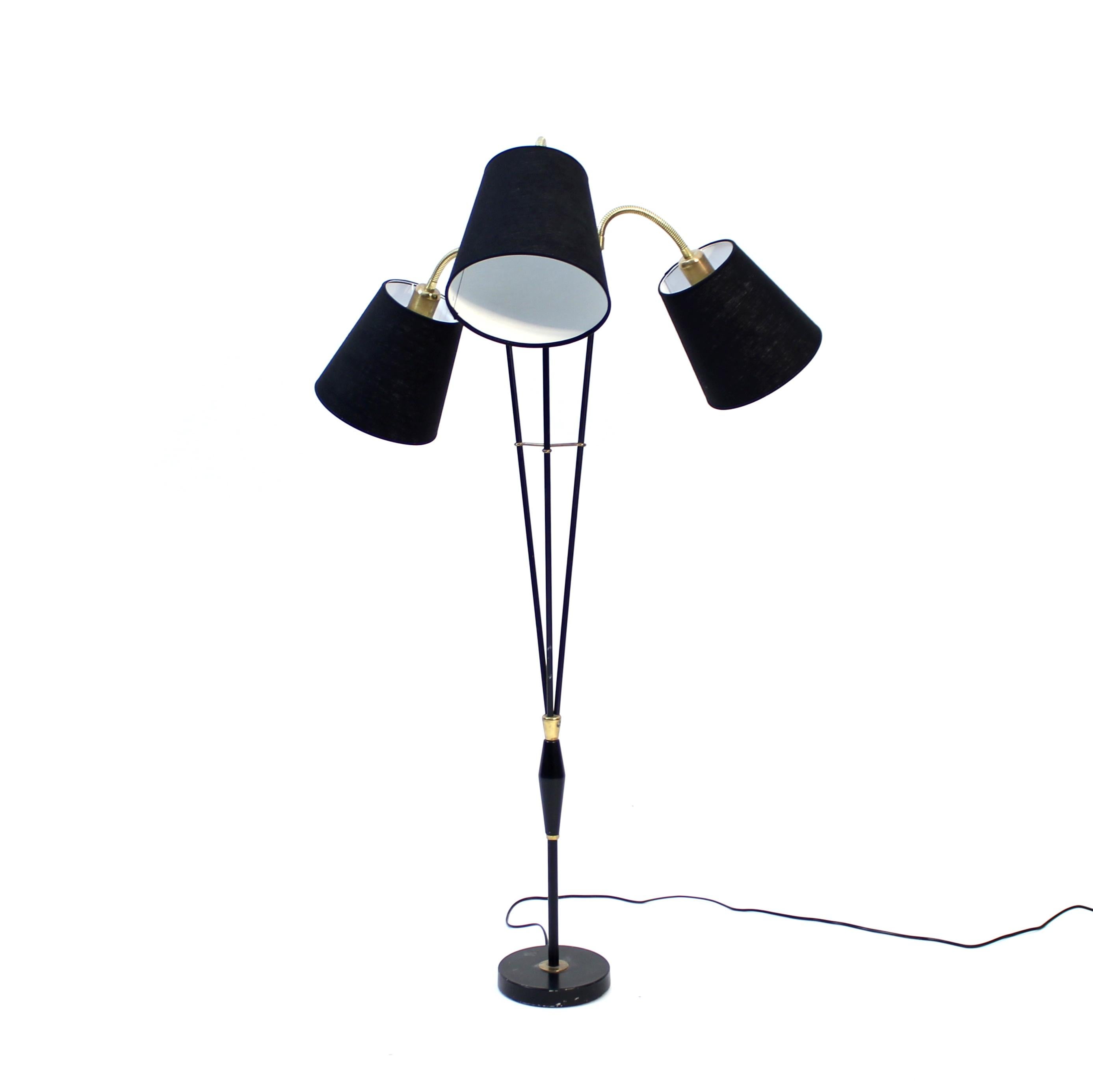Swedish mid-century floor lamp with three adjustable swan neck light sources, mounted on different heights. Black metal stem with brass details. Fitted with three new black shades. Good and honest vintage condition with light ware consistent with