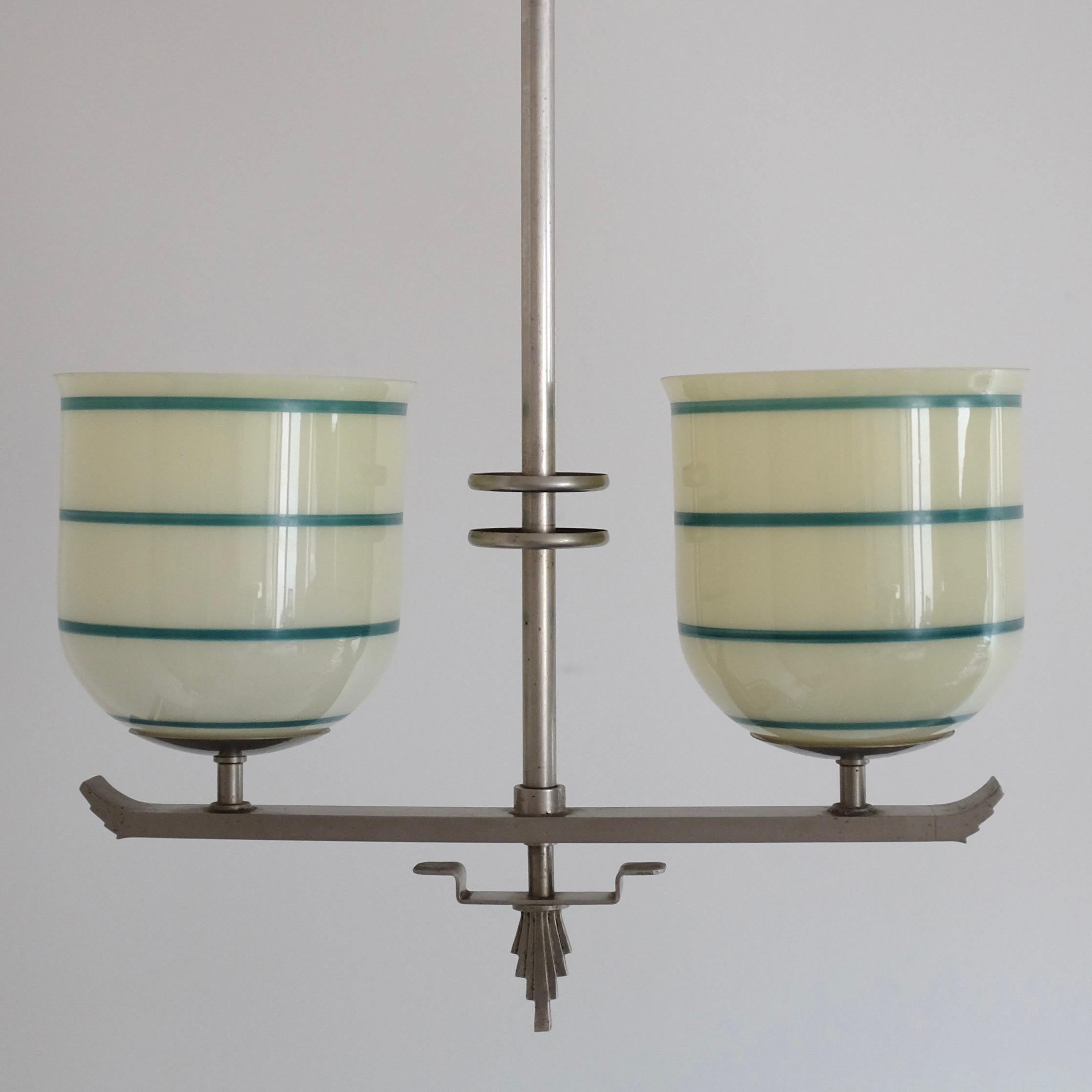 Wunderschöner schwedischer Anhänger aus Glas und Zinn aus der Mitte des Jahrhunderts. Der aus Zinn gefertigte Lampenarm ist im neoklassischen Stil mit zwei dekorativen Glaslaternen auf jeder Seite gestaltet. Die Laternen haben eine cremefarbene
