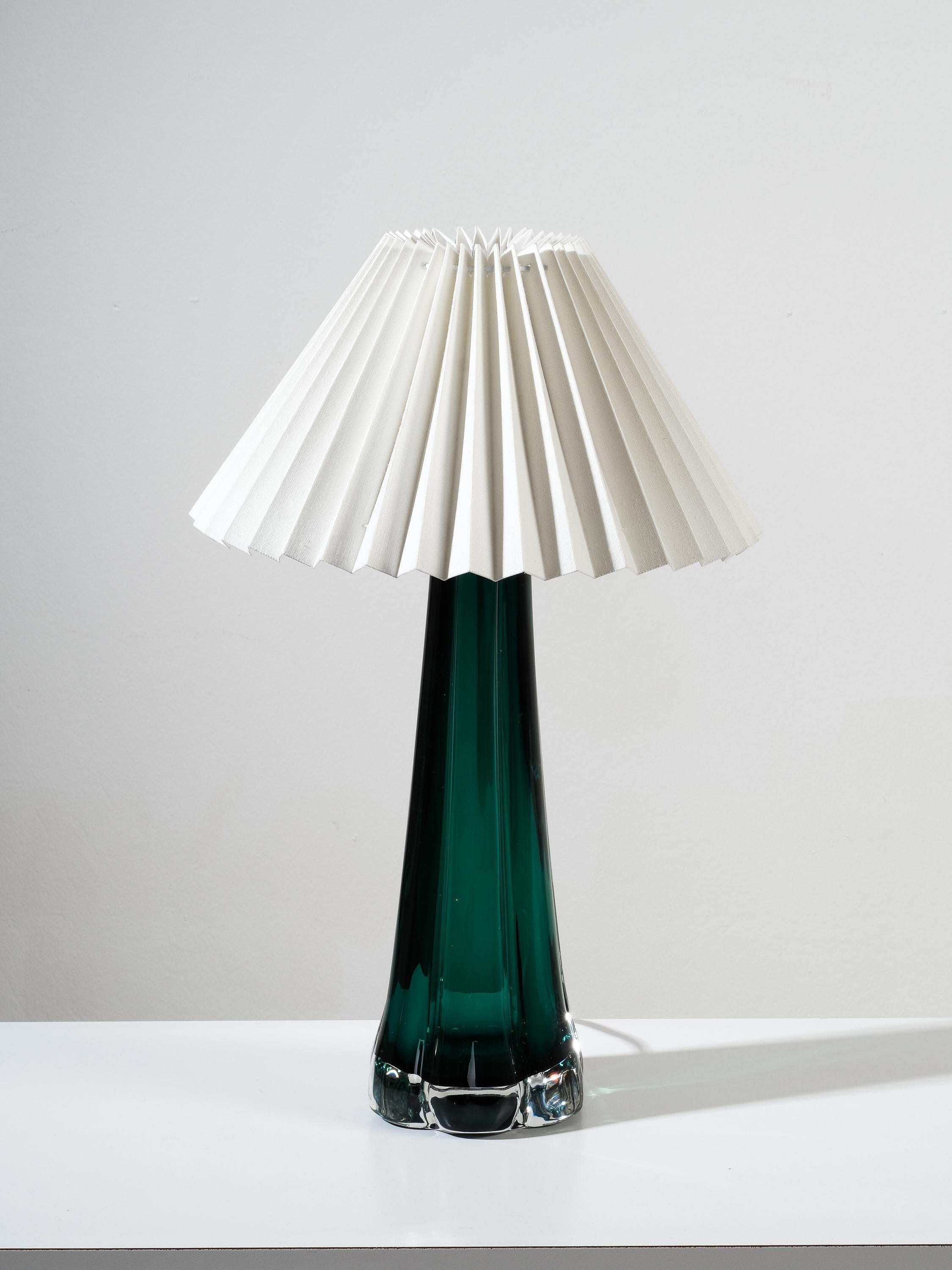 Classy green glass table lamp by Swedish manufacturer Kosta Elarmatur in the 1960s. New white pleated fabric shade.

Labeled on the bottom. Good vintage condition with minimal wear, consistent with age and use.