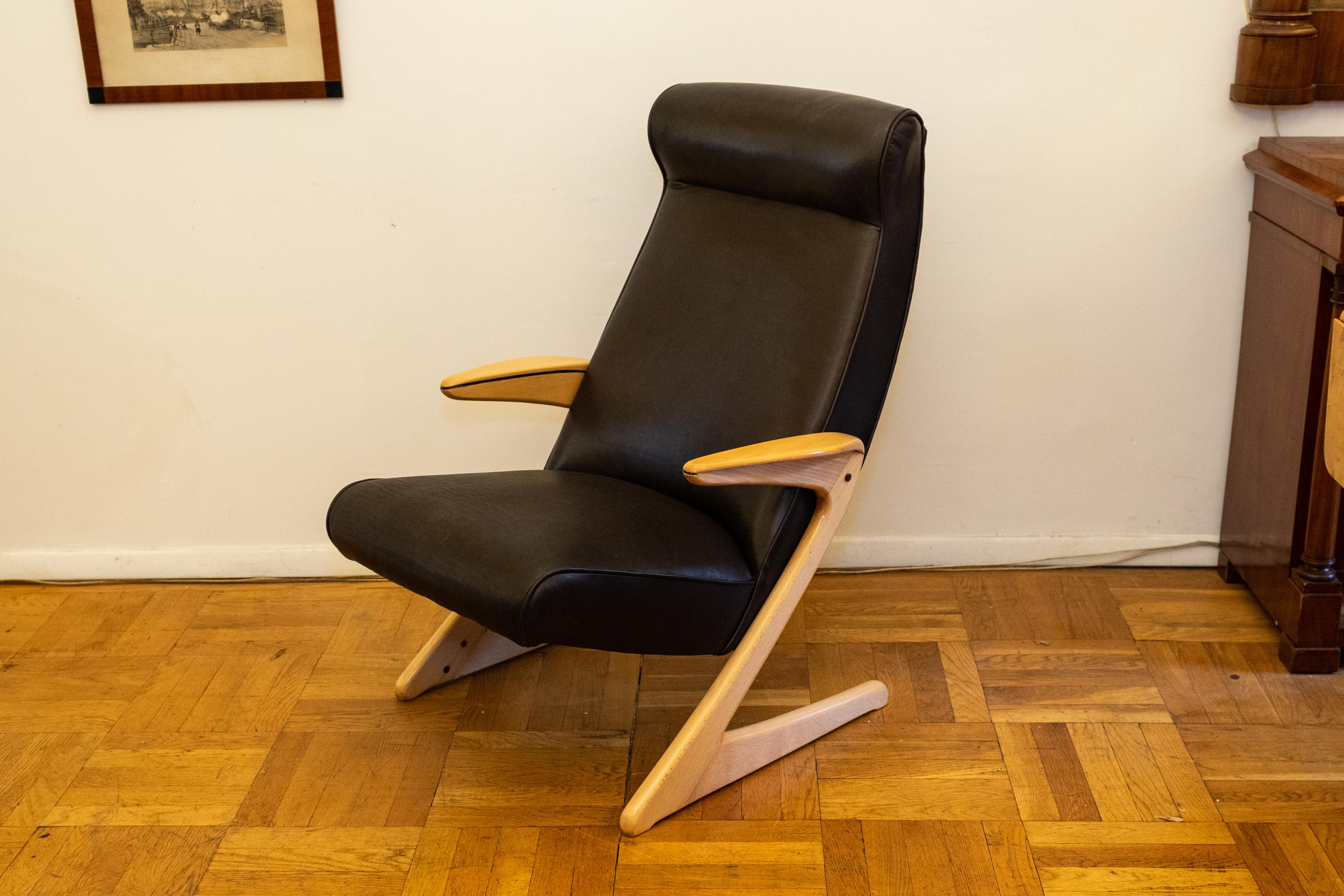 Une chaise confortable au design minimaliste époustouflant et à l'assise en cuir doux comme du beurre.  Les accoudoirs et les pieds de cette chaise sont boulonnés directement à l'armature de l'assise et du dossier qui dissimule les supports