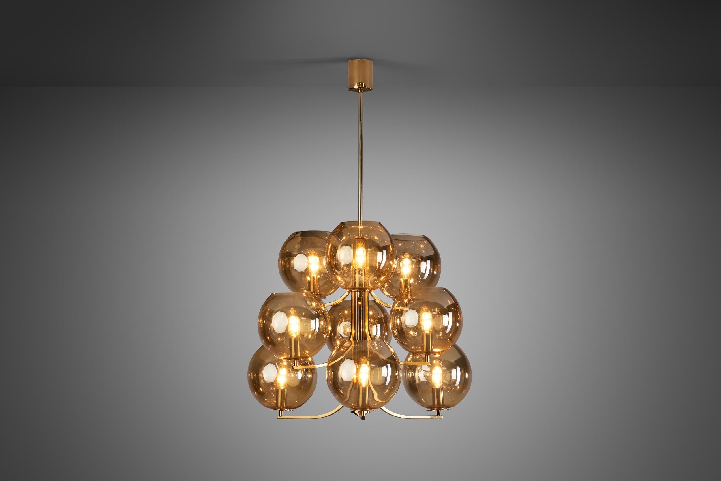 This rare, brass nine-armed chandelier was created in what we now call “the golden age of Scandinavian design”. Swedish designers were masters of lighting, designing some of the most recognizable mid-century modern lamps of Scandinavia.

With nine