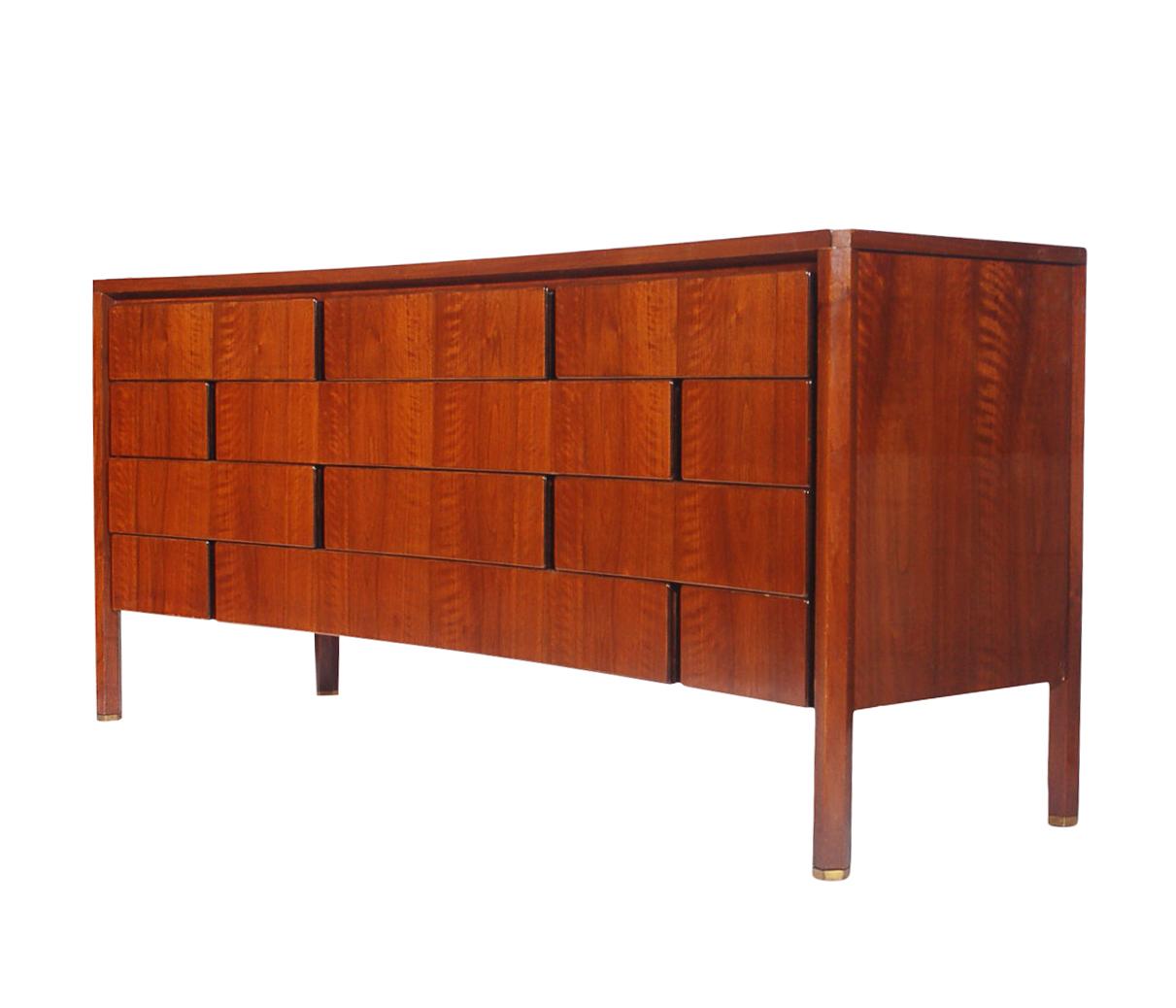 A stunning and incredibly built complete bedroom set designed by Edmond Spence in Sweden. Incredible curved fronts with unique drawer layout. It features solid wood construction with gorgeous walnut wood grain. Hexagonal legs with brass end caps. In