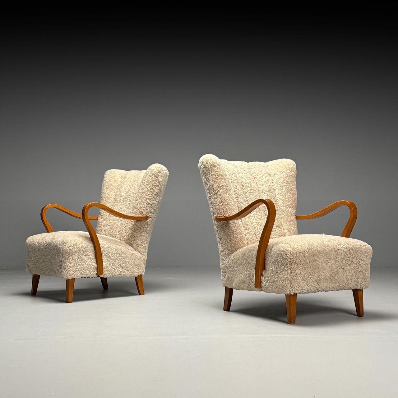 Scandinavian Mid-Century Modern, Wingback Lounge or Arm Chairs, Beige Sheepskin, Oak, Sweden, 1940s

A pair of Swedish modern lounge chairs from the first half of the 20th century, featuring newly upholstered beige genuine sheepskin, channeled