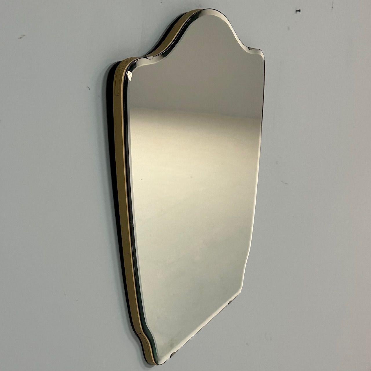 Swedish Mid-Century Modern, Small Wall Mirror, Shield Form, Sweden, 1970s

Mid-century modern mirror designed and produced in Sweden in the later half of the 20th century. This shield form mirror has a beveled edge, wooden back, and four brass