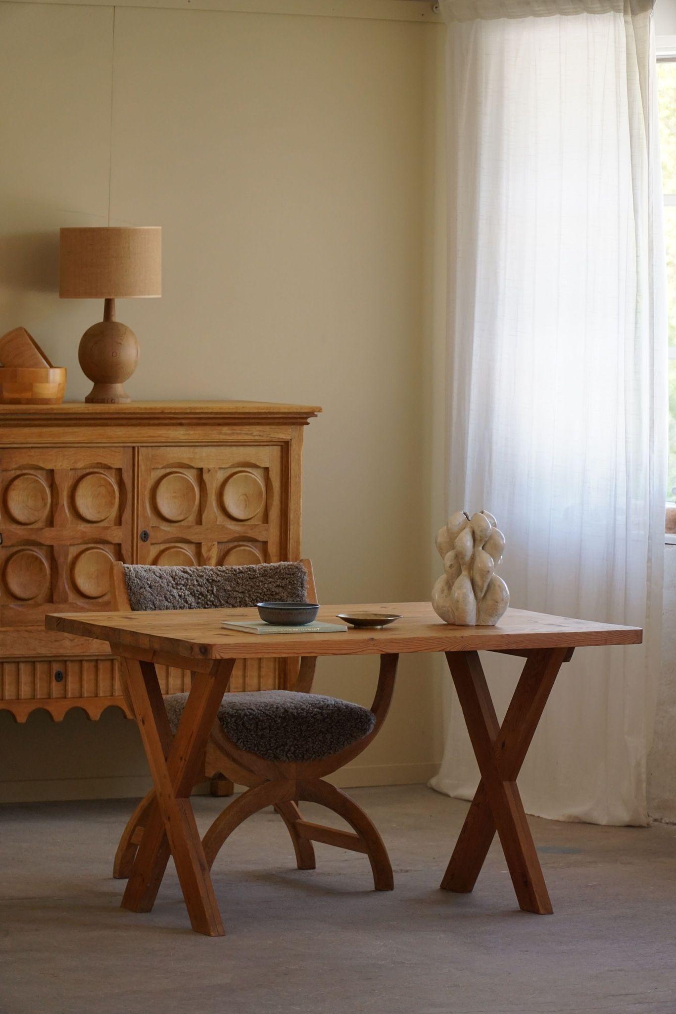 A charming mid-century solid pine desk / dining table with visible dowels and a fine X frame. Hand crafted by a Swedish cabinetmaker in 1960s. Made in the style of Roland Wilhelmsson. 

A beautiful figure with some lovely details that will