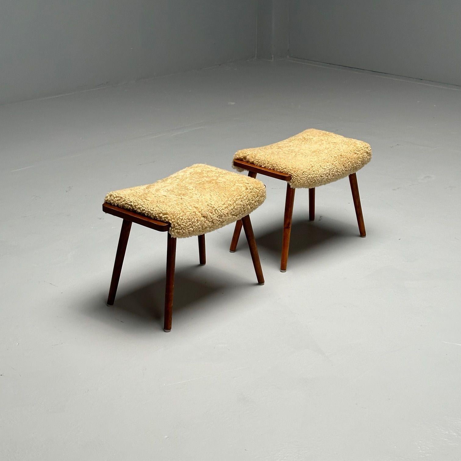 Poufs ou ottomans suédois du milieu du siècle, peau de mouton miel, noyer, Suède, années 1970

Paire de poufs ou ottomans modernes suédois ; chaque exemplaire présente quatre pieds en noyer légèrement inclinés et des dessus rembourrés récemment