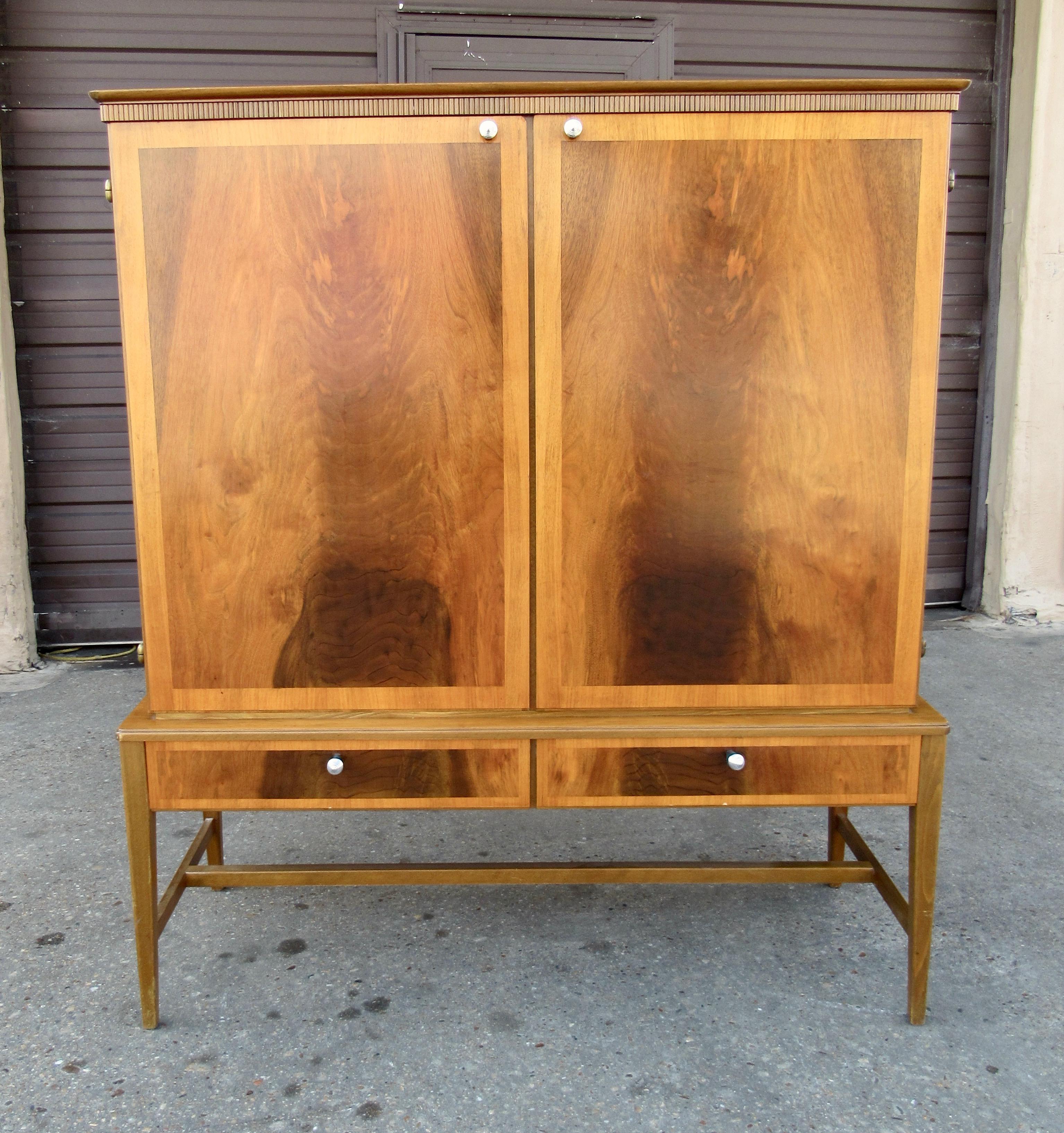 Swedish Mid-Century Modern storage cabinet in beech with inlaid, book matched walnut door panels. Interior consists of adjustable shelves and pull out / pull-out drawers. With bronze hinges.
This item has been lightly restored by our crafts men and