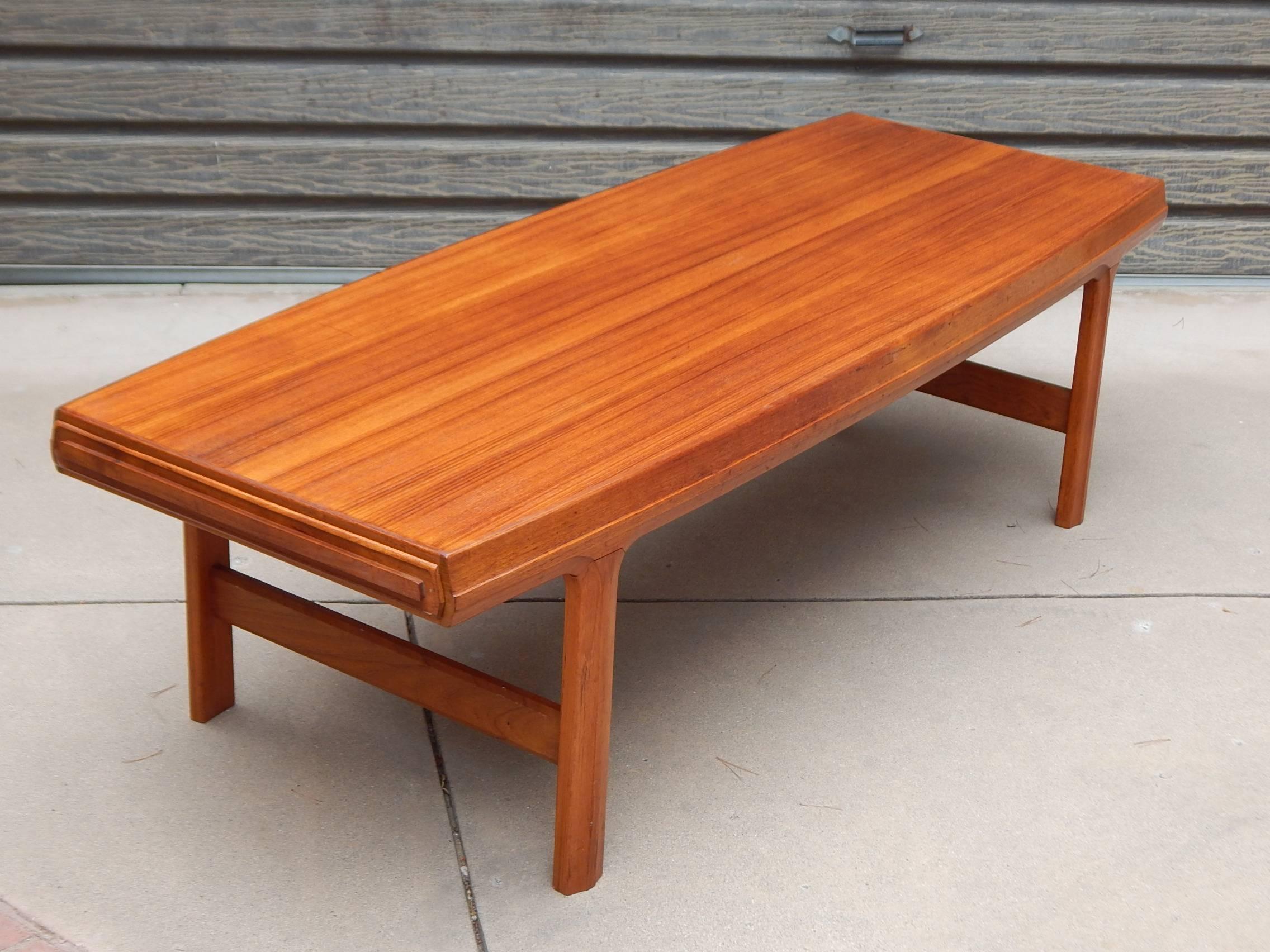 Swedish Mid-Century Modern teak coffee table with hidden retractable side drawers, circa 1960. In excellent original condition with some wear and surface scratches. See the detailed photos for more info. There are drawers on both sides of this item.