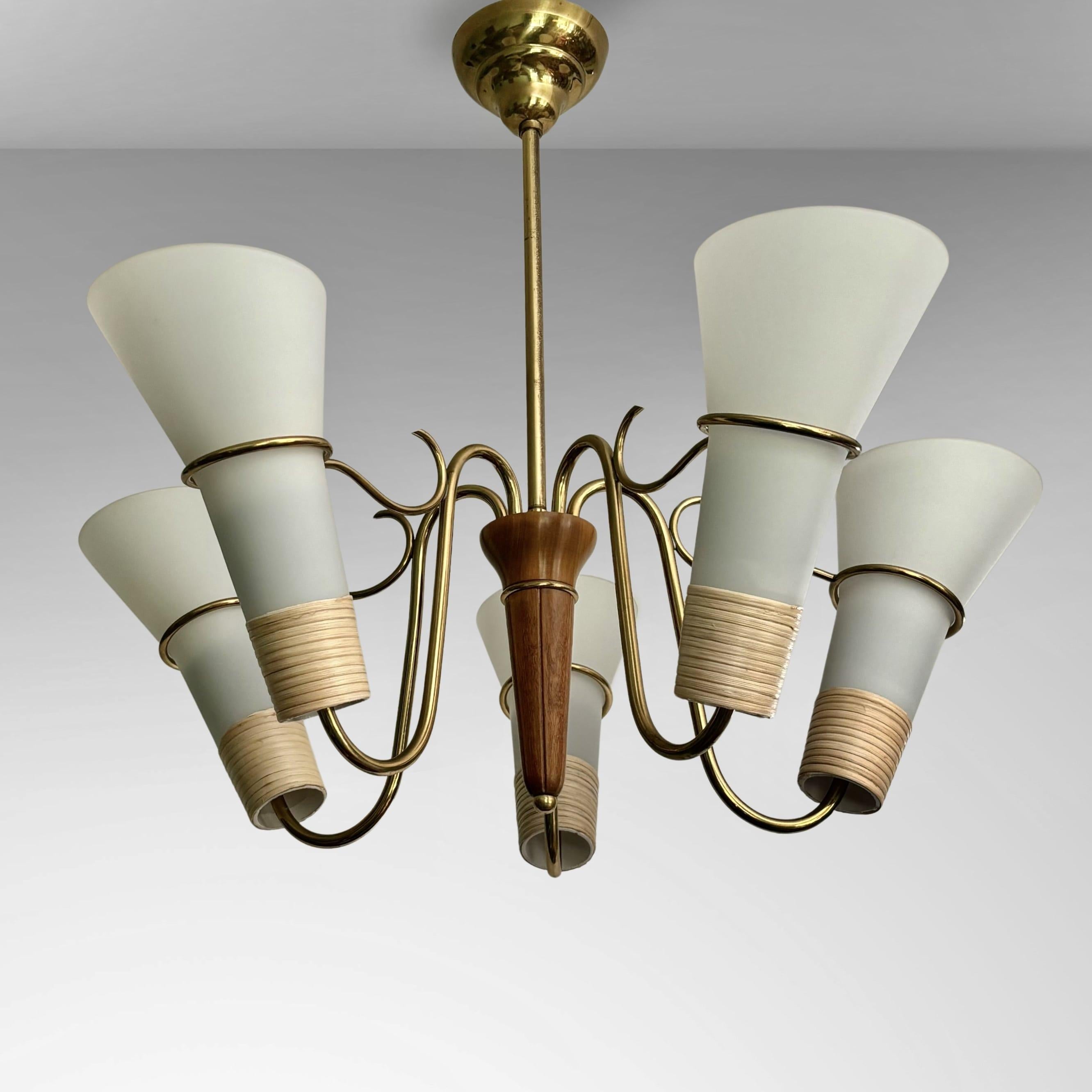 A large and impressive Swedish 1940s chandelier made from brass, featuring five curved arms holding cone-shaped shades in opal glass. Each shade is partially wrapped in rattan and secured by a decorative brass ring. The five arms are connected by a