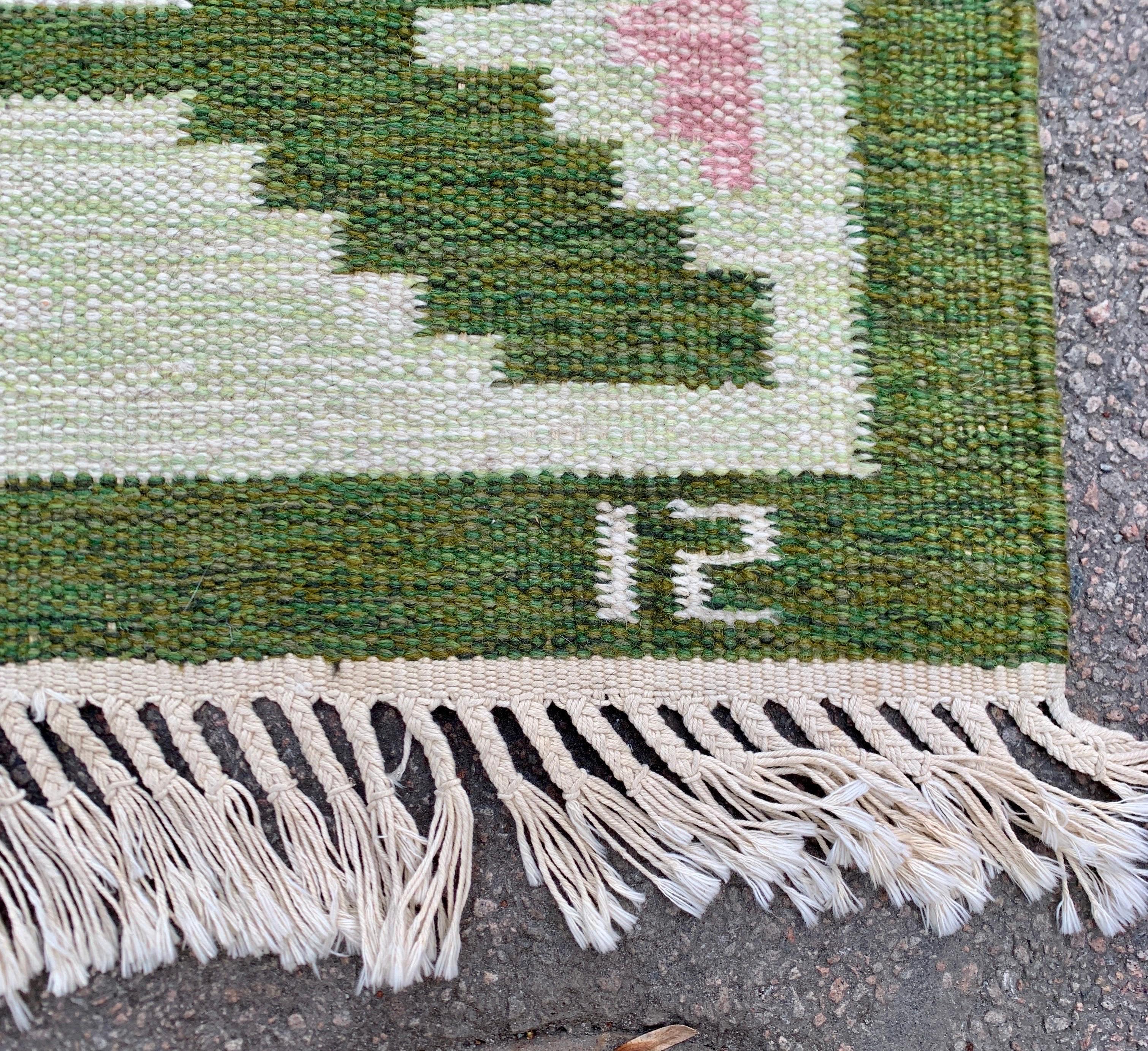 A Mid-Century Modern vintage handmade Swedish carpet in wool featuring a  geometric pattern. This greenish colored Scandinavian rug is made and signed by Swedens famous designer Ingegerd Silow. Her artwork is getting more and more appreciated