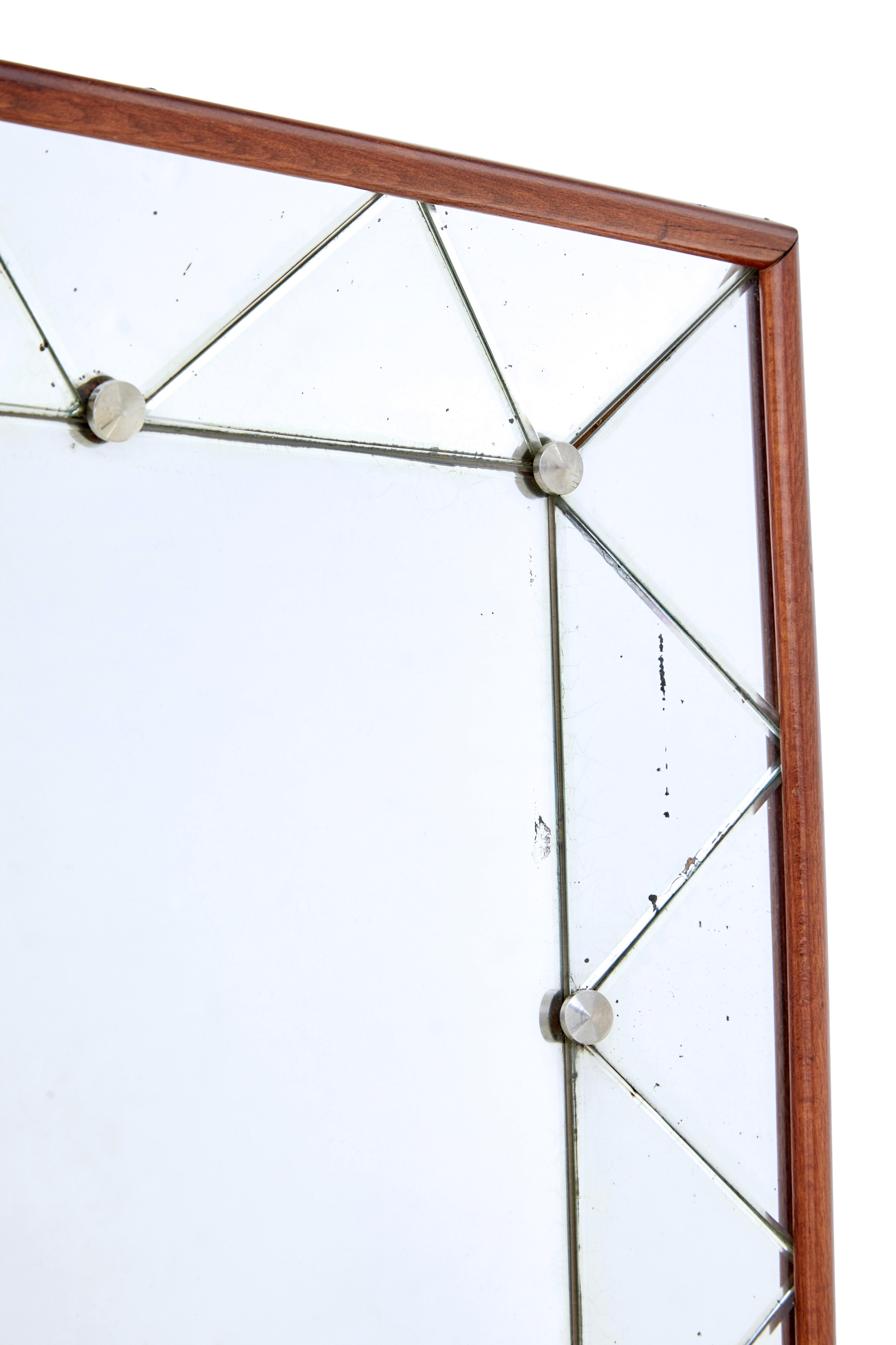 Swedish mid century shaped wall mirror circa 1960.

Inverted cushion shaped mirror ideal for most rooms around the home.

Teak frame, with a central rectangular mirror surrounded by a border of triangular cut mirror pieces, held in place by chromed