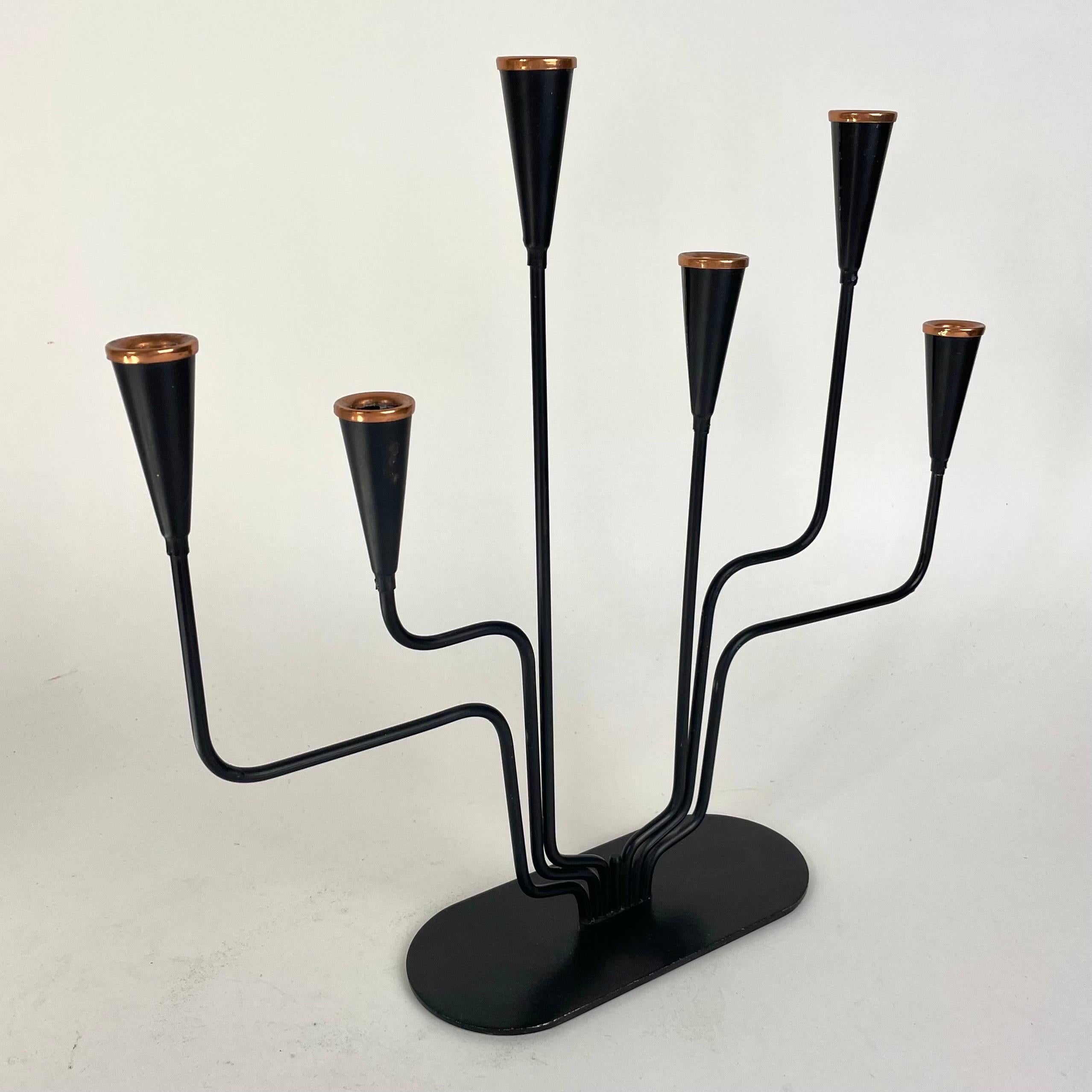 Llamativo Candelabro Sueco Moderno de Mitad de Siglo de Seis Brazos, de Hierro Lacado en Negro y con Detalles de Latón en Forma de Bobèches Modernistas. Suecia, años 50

Un candelabro armoniosamente asimétrico, muestra la sensibilidad de mediados de