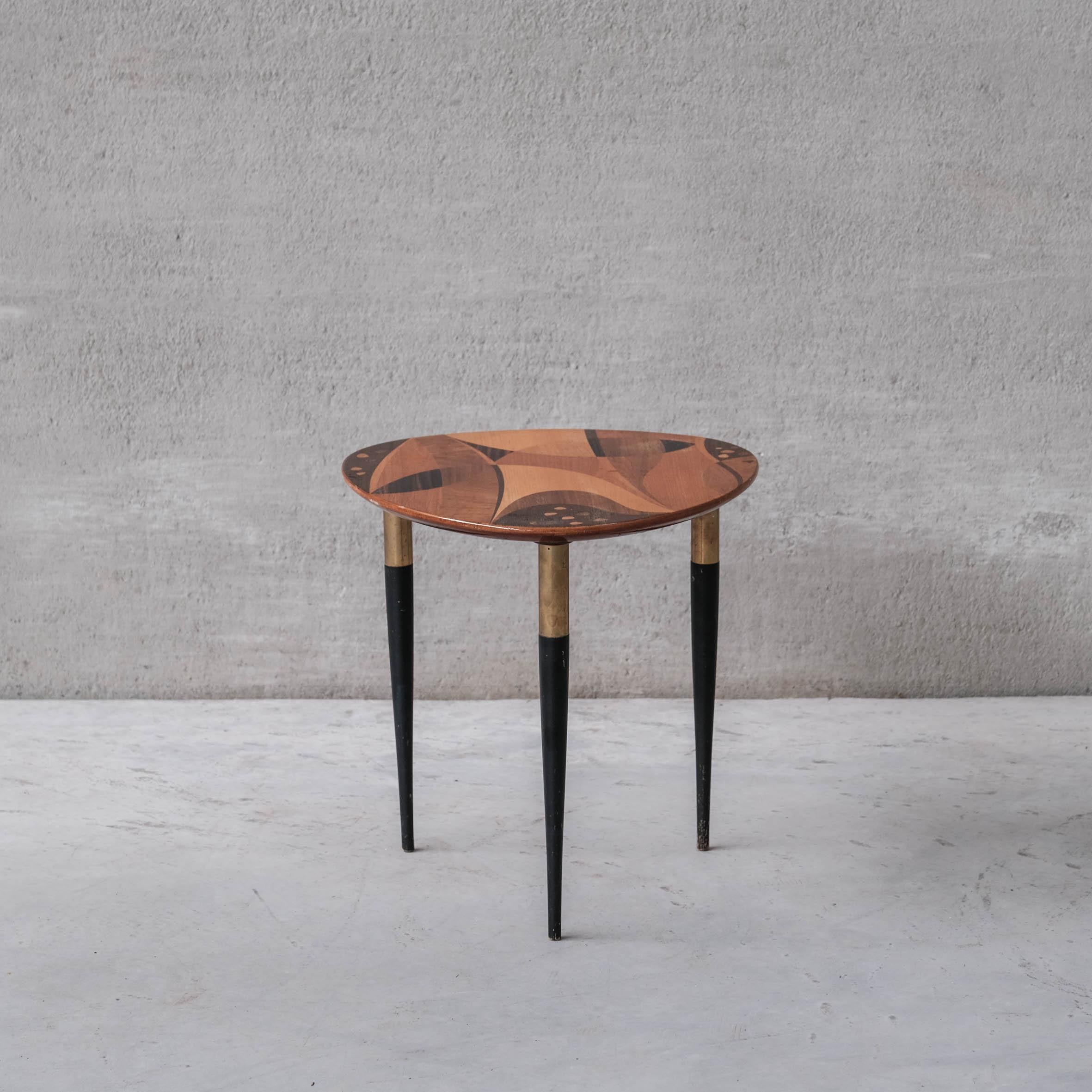 An unusual multi-specimen wood side table of remarkable quality. 

Sweden, c1960s. 

Manufactured for Bodafors. 

Lacquered black wooden legs with brass detailing, support intarsia style wooden top of intriguing form. 

Lightly stamped to