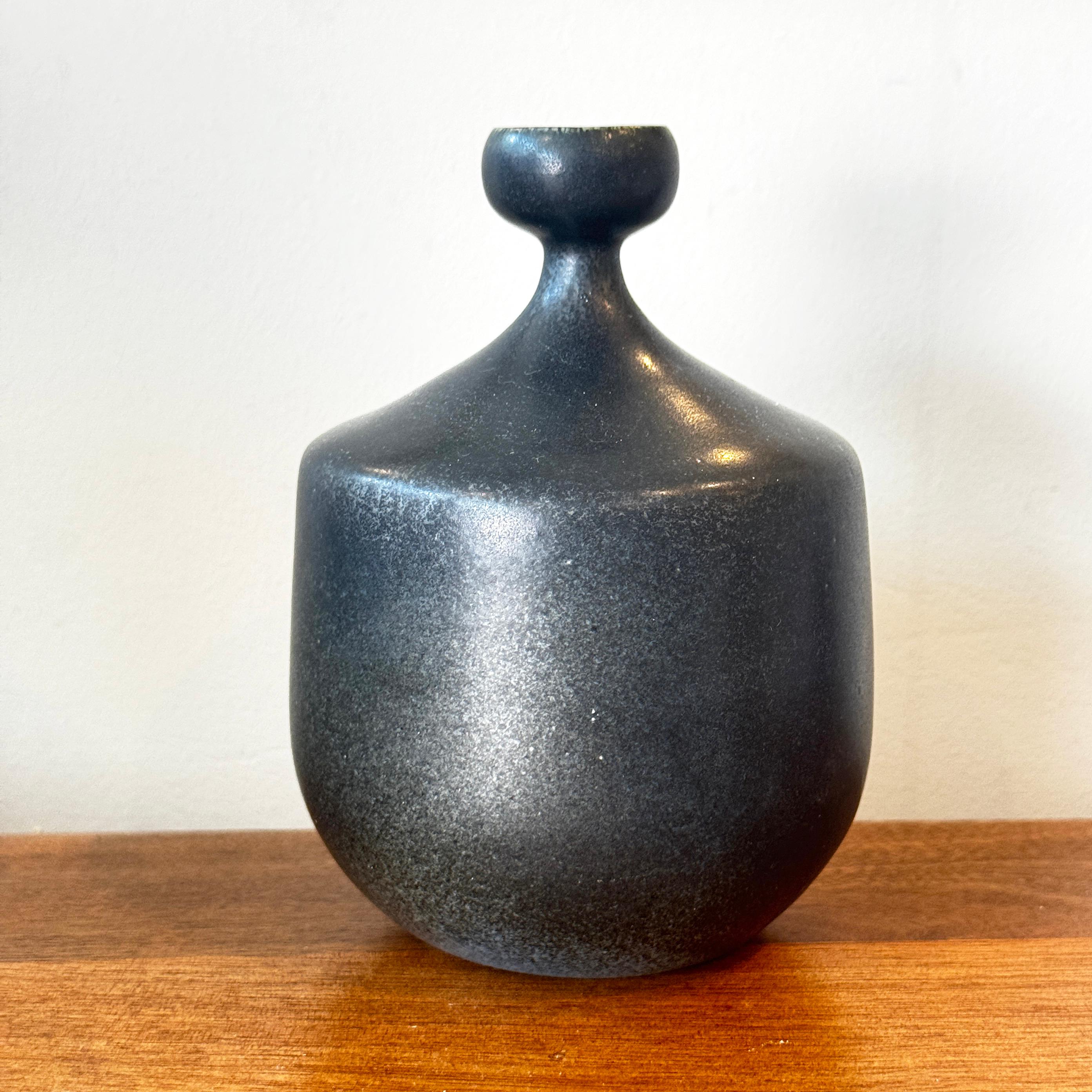 Diese schwedische Studio-Keramikvase von Agne Aronsson hat eine wunderbar skulpturale Form mit einem sich sanft verjüngenden Hals, der von einer zarten becherförmigen Öffnung gekrönt wird. Die Vase ist mit einer zarten schwarzen Glasur überzogen,