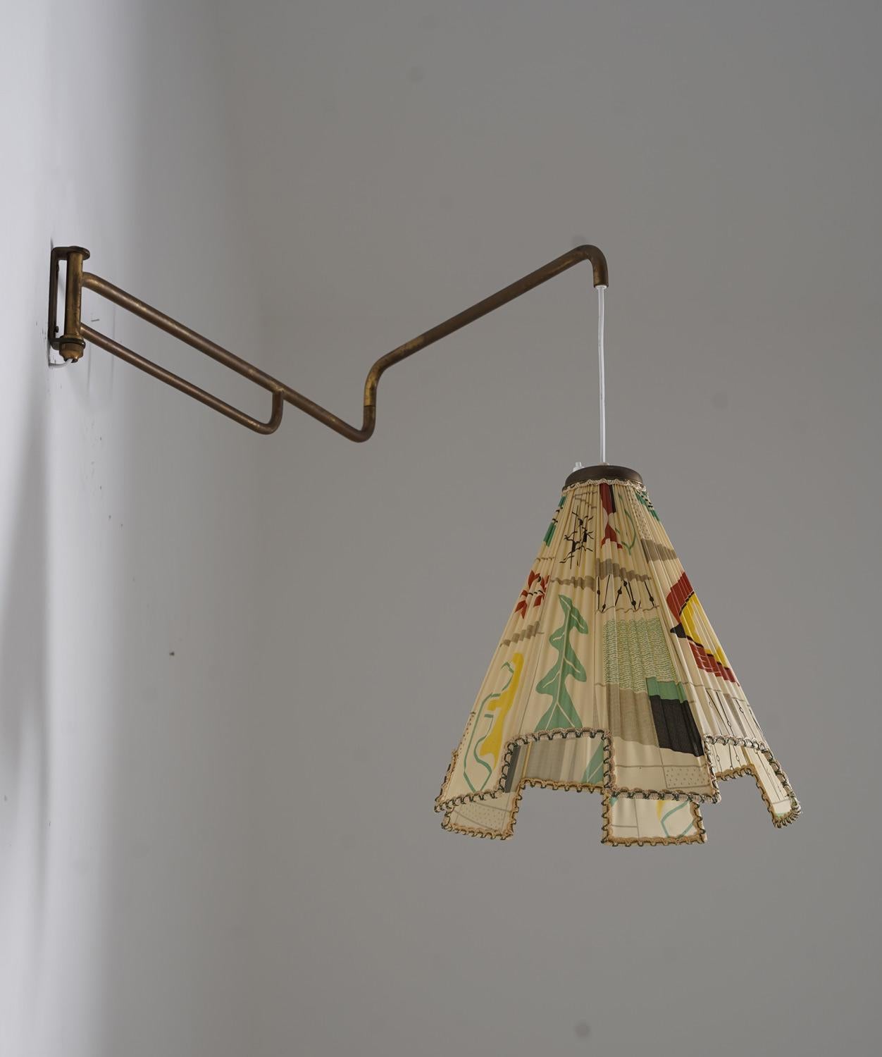 Beautiful swivel arm wall lamp manufactured in Sweden ca 1950. The large shade is adjustable in height, by sliding the wire to any length that you prefer.
The total length of the arm is 110cm (43