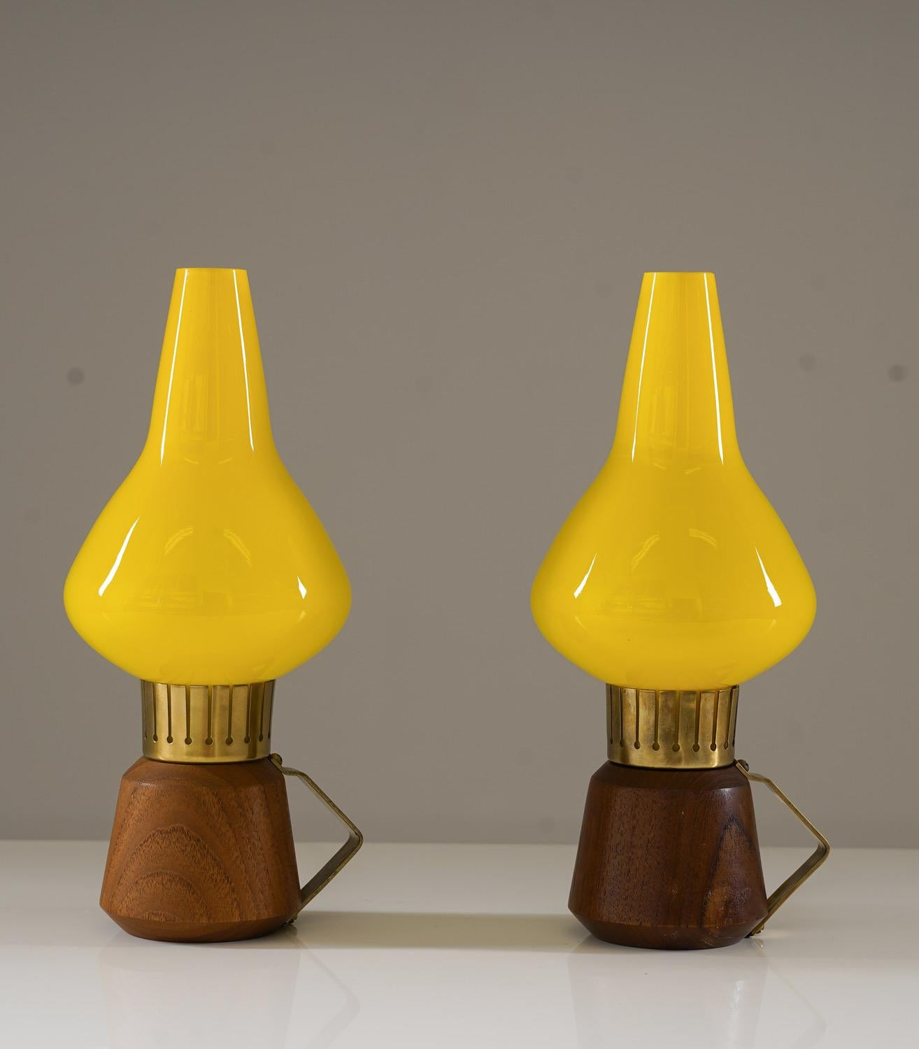 Un'affascinante coppia di lampade da tavolo svedesi della metà del secolo scorso, prodotte da ASEA negli anni Cinquanta. Queste lampade, piccole ma di grande effetto, presentano una base scultorea in teak dal design sfaccettato, completata da