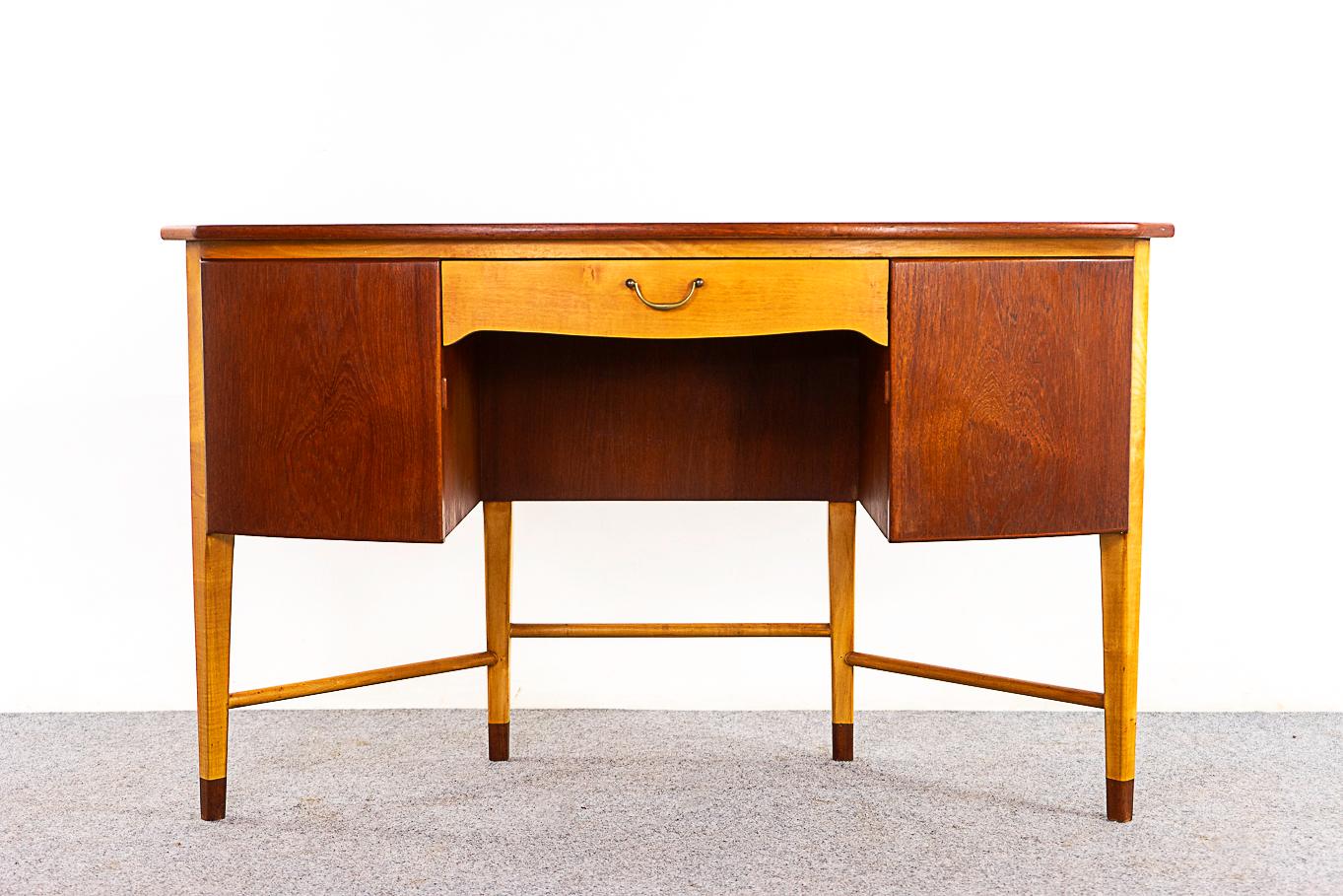 Teak & beech vanity/desk, circa 1950's. Unique shape with triangular storage cubbies and sleek drawer. A combination of teak veneer and contrasting beech throughout. Cross bars add stability to the capped legs. 

Unrestored item with option to