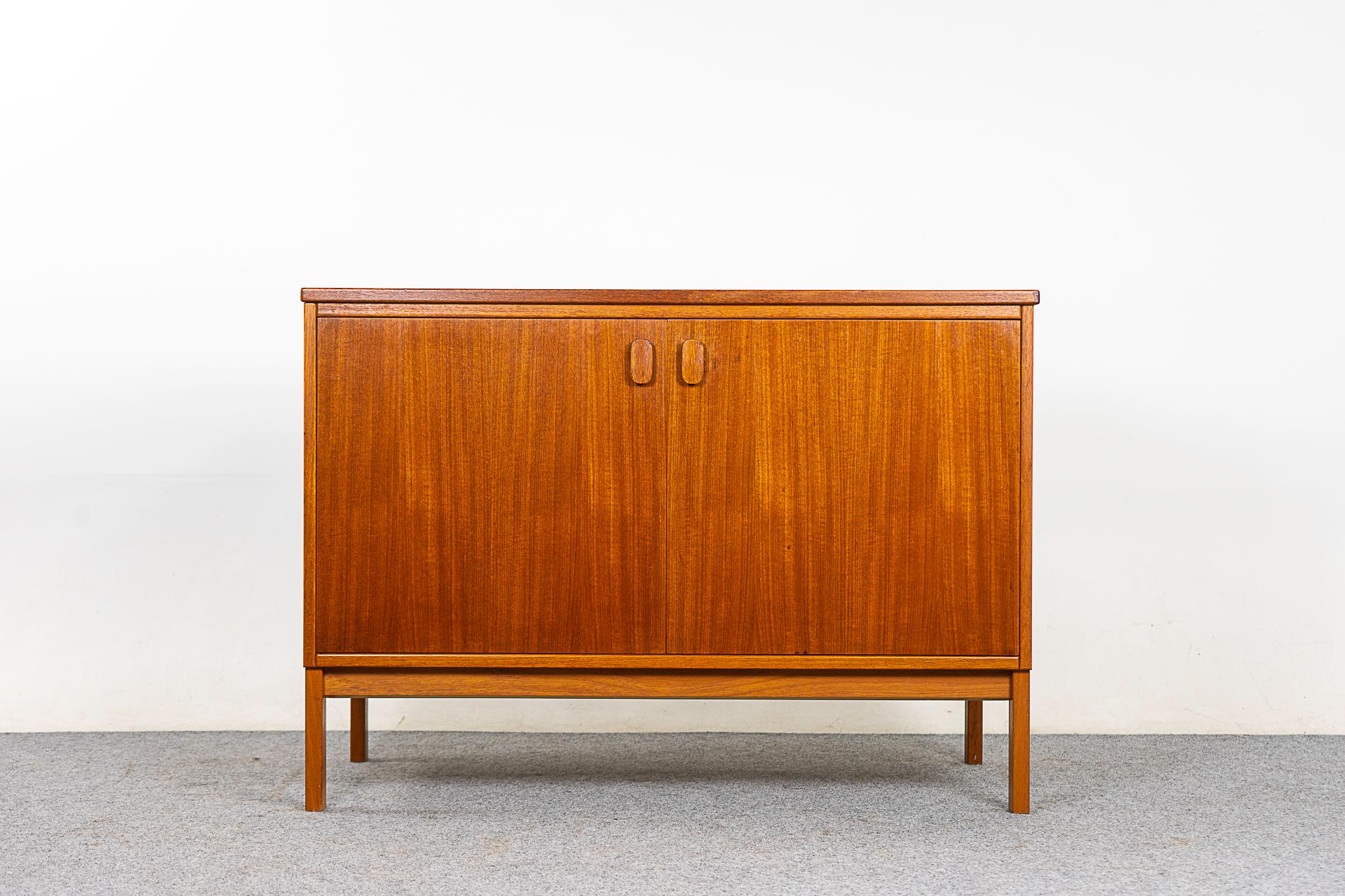 Teak double door cabinet by Ulferts, circa 1960s. Clean, simple lined design highlights the exceptional book-matched veneer. Small interior drawers and adjustable shelf, a perfect condo sized storage solution.

Unrestored item, some marks consistent