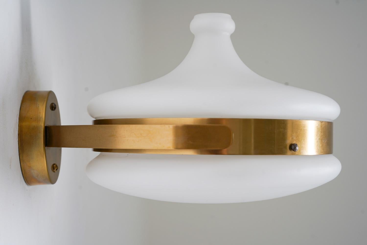 Seltene Wandlampen aus der Mitte des Jahrhunderts aus Messing und Opalglas von Falkenbergs Belysning, Schweden, 1960er Jahre. 
Diese Lampen haben einen Schirm aus mattiertem Opalglas, der auf einem Gestell aus Messing ruht. 

Zustand: Sehr guter