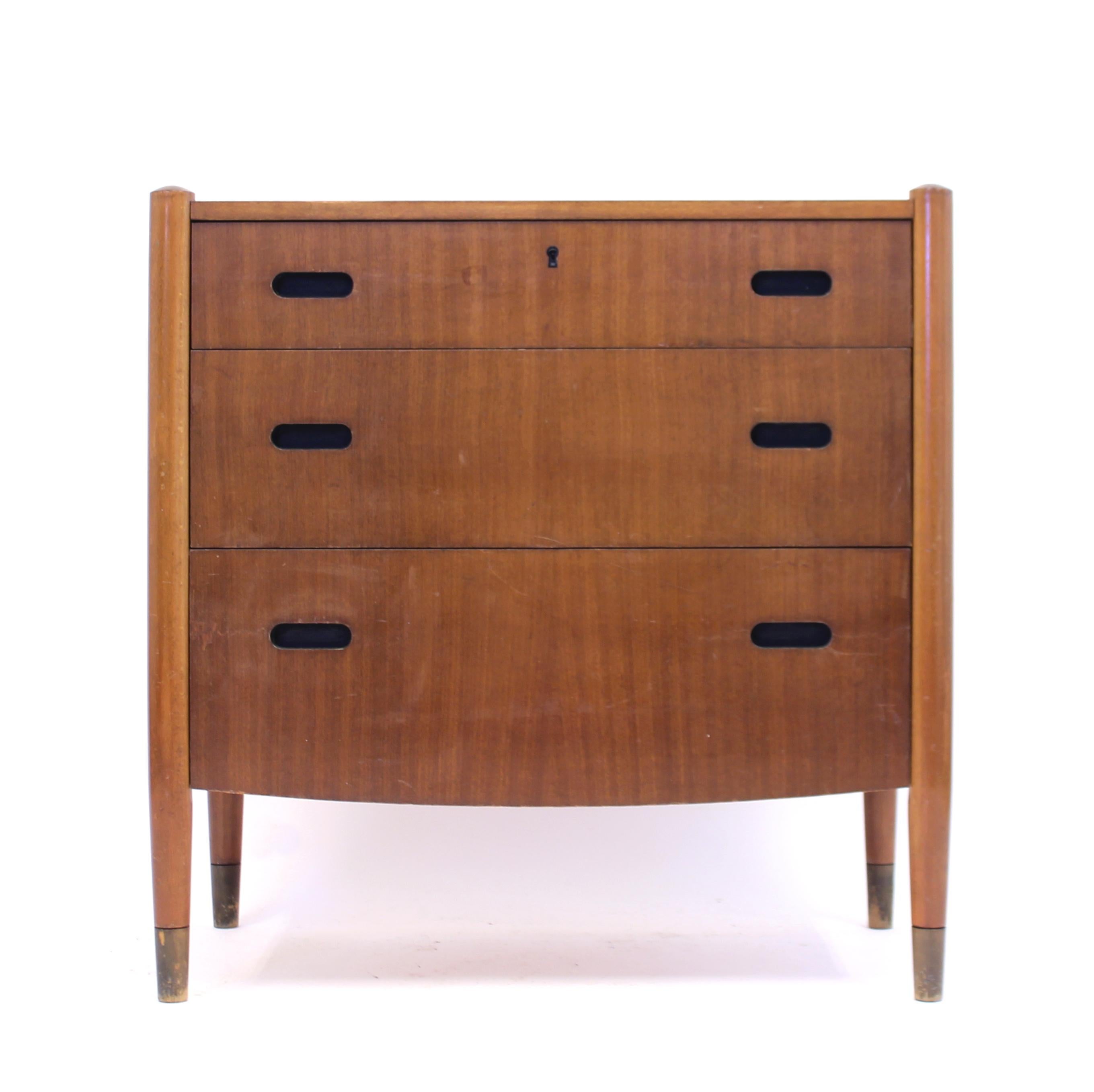 Swedish mid-century Zebrano chest of drawers in a minimalist style. Unusual detail  of the lowest drawer that is slightly curved at the bottom which makes the overall shape a bit more interesting. The handles are just cut two out wholes at the front