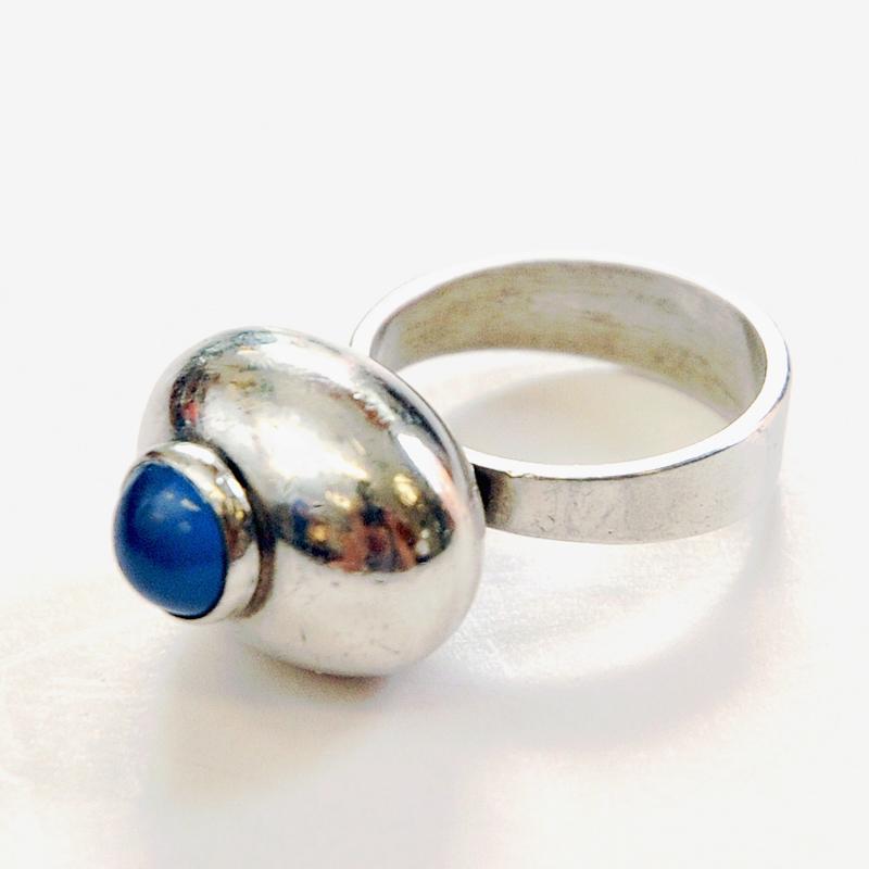 Lovely silverring with a small round blue stone in the middle lying on a silver bubble. This silver ring is produced by Ge Kå Smycken Kaplan,  Stockholm, Sweden 1967. Good vintage condition and natural patina. Marked with silverstamp and GK R9 S.