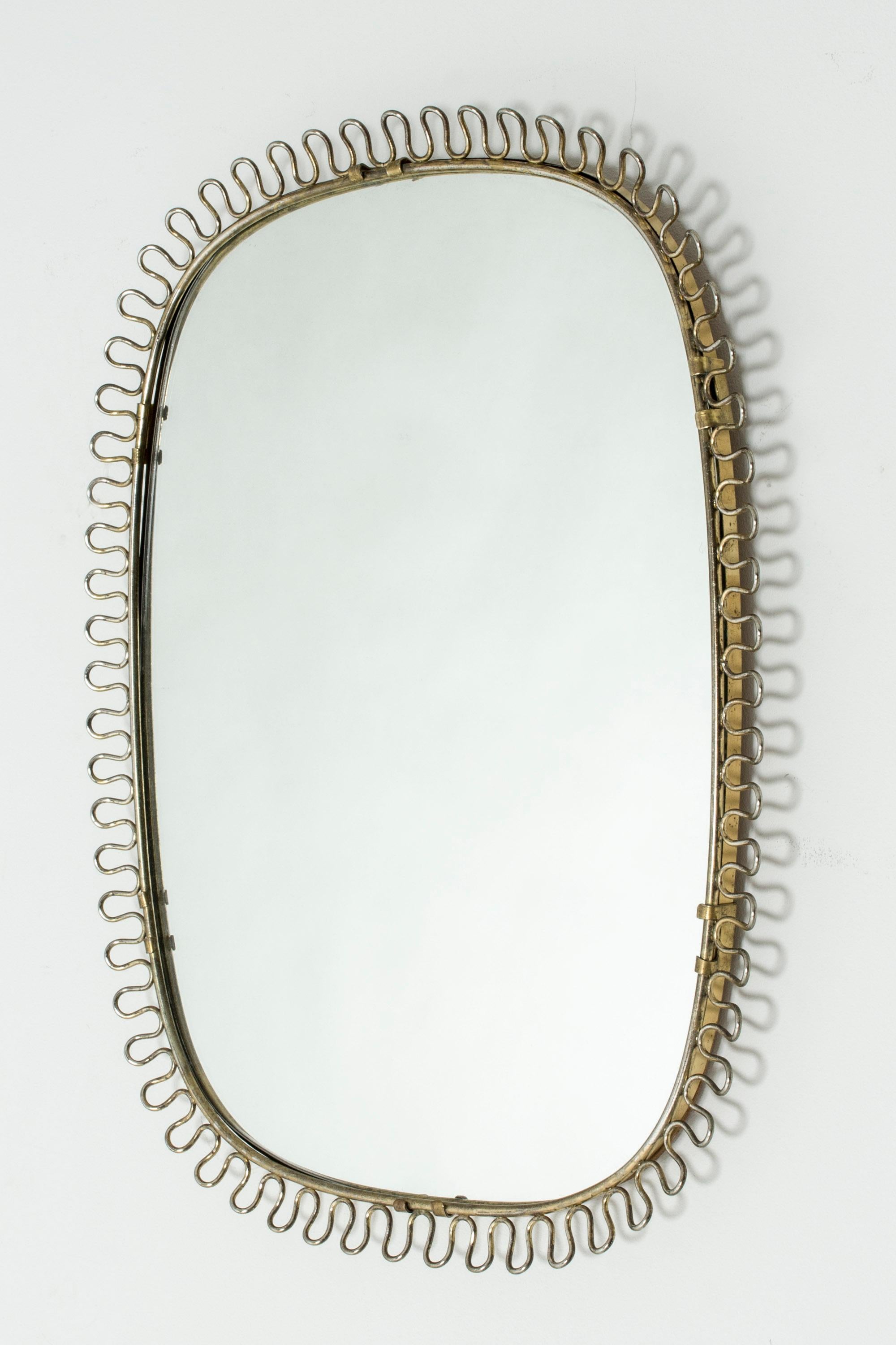 Lovely Swedish midcentury wall mirror in the style of Josef Frank. Made with a brass frame decorated with a wavy edge.