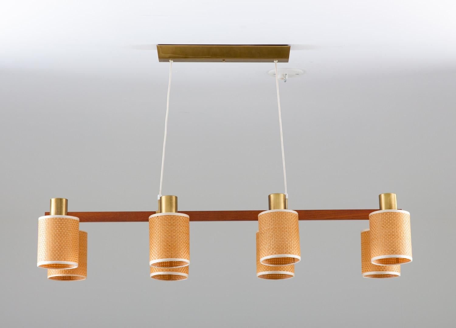 Very rare midcentury ceiling lamp by Hans Bergström for Ateljé Lyktan, Sweden.
This lamp consists of a teak frame with four arms in brass, each holding two light sources. The original shades are made of rattan, giving a soft, ambient light.